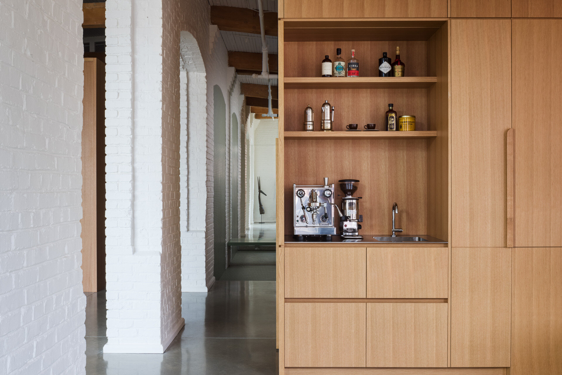 A Montreal loft where industrial history meets warm minimalism. White oak volumes and original brick details create a space that's both raw and refined.
