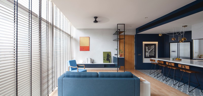Neutral walls and timber floors contrast with custom black shelving, marking the transition from old to new in this refined living area.