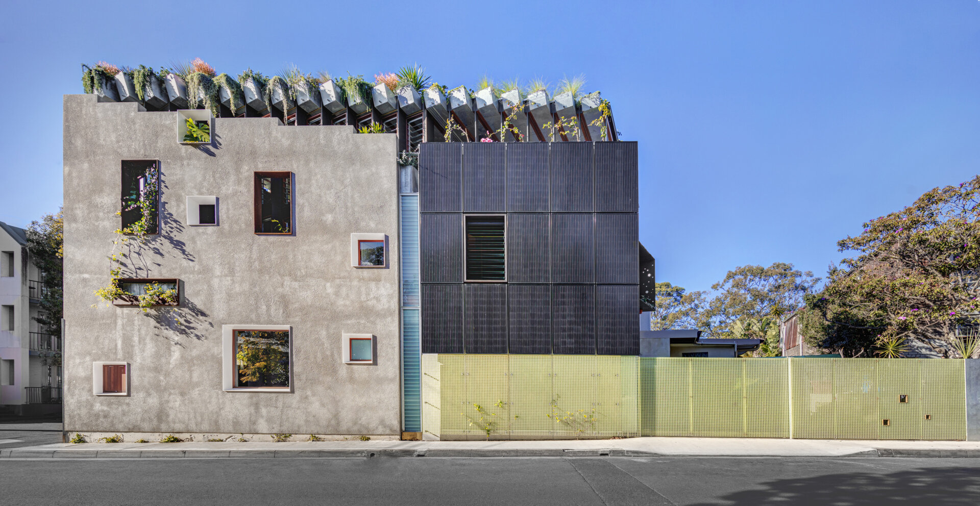 A black photovoltaic panel array punctuates the new northern facade, clearly signaling the home’s commitment to sustainability. These solar panels harness sunlight throughout the day, generating renewable energy to power the household.