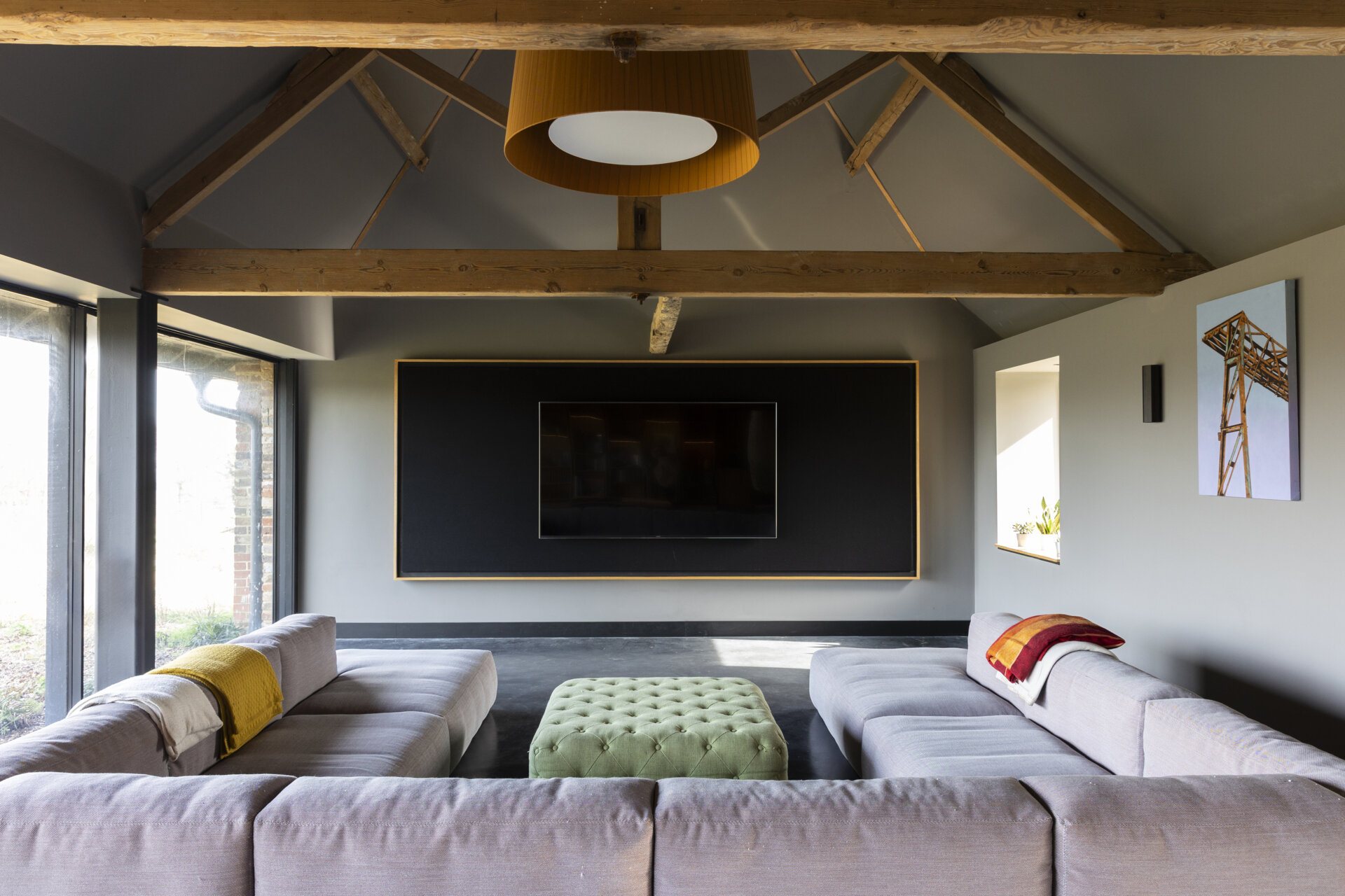 Upstairs, the family room and media space offer a more casual zone for daily life. Layered with contemporary furniture, the space strikes a relaxed tone, perfect for movie nights or quiet afternoons at home.