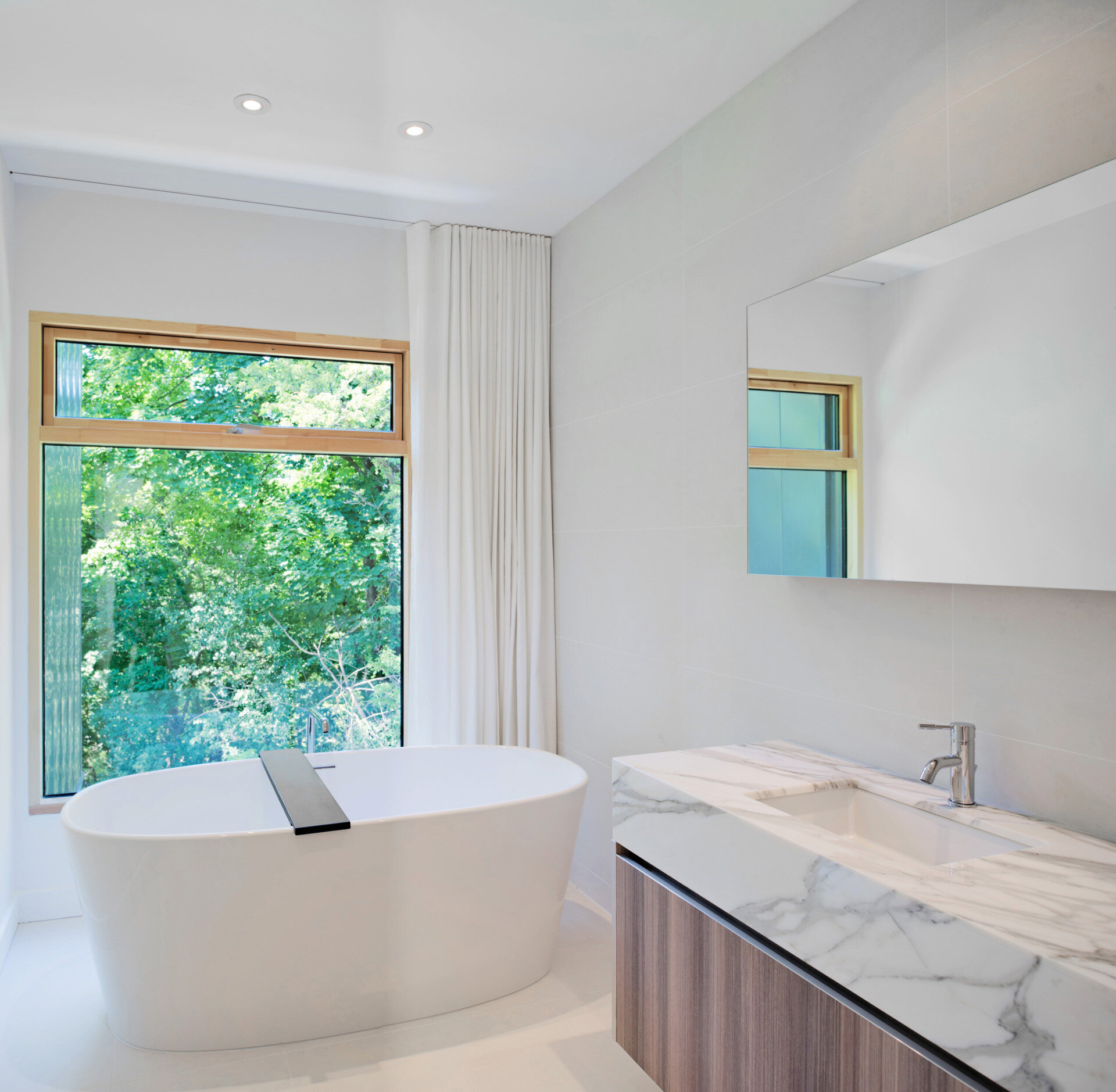 The bathroom continues the home’s clean lines and subtle palette. Designed for comfort and functionality, it balances minimalist materials with everyday usability, reinforcing the sense of calm that runs throughout the residence.