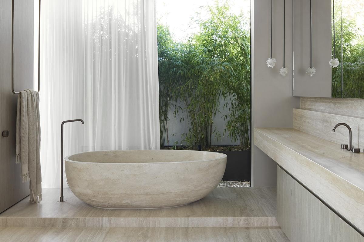 Cantilevering over the alfresco zone, the ensuite bathroom becomes part of the landscape. Textured materials and thoughtful sightlines reflect the home's indoor-outdoor rhythm.