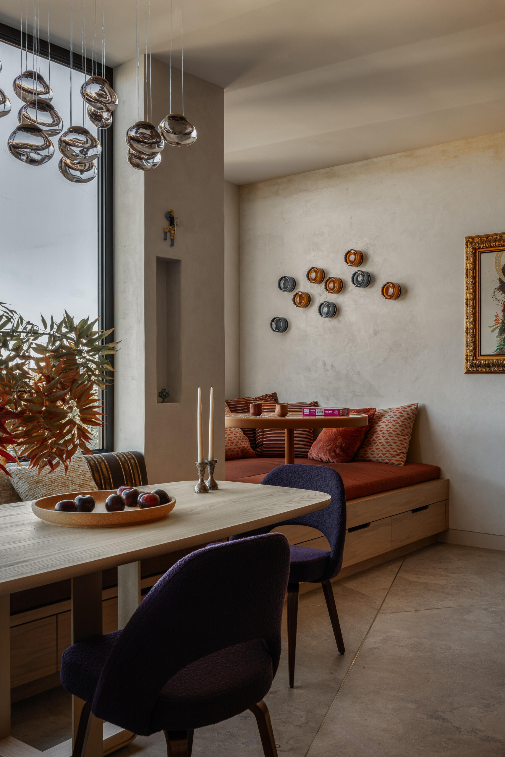 Just past the dining area, a custom bay window nook brings a playful architectural moment. The built-in seating is paired with a resin-topped, rotating game table that invites spontaneous board games or lazy weekend lounging.
