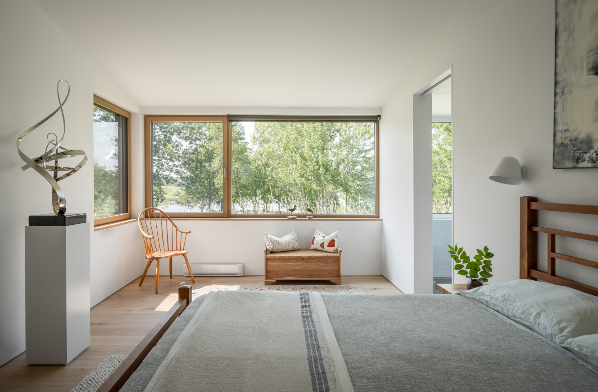 Clean lines, quiet light, and warm wood make the bedroom a restful retreat that stays cozy all year thanks to Passive House performance.