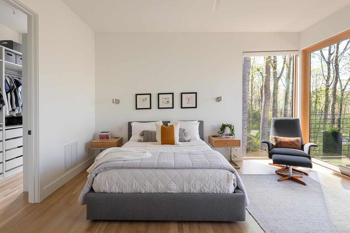 A primary bedroom, designed as a private sanctuary with its own quiet deck that looks out onto the landscape.