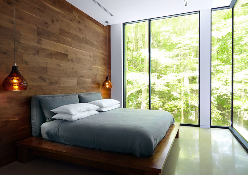 In the bedroom, nature comes inside in more than just the views. A wood-covered feature wall channels the surrounding forest, bringing texture and warmth to the serene space. Simple, calming, and grounded, the room is a retreat within a retreat.