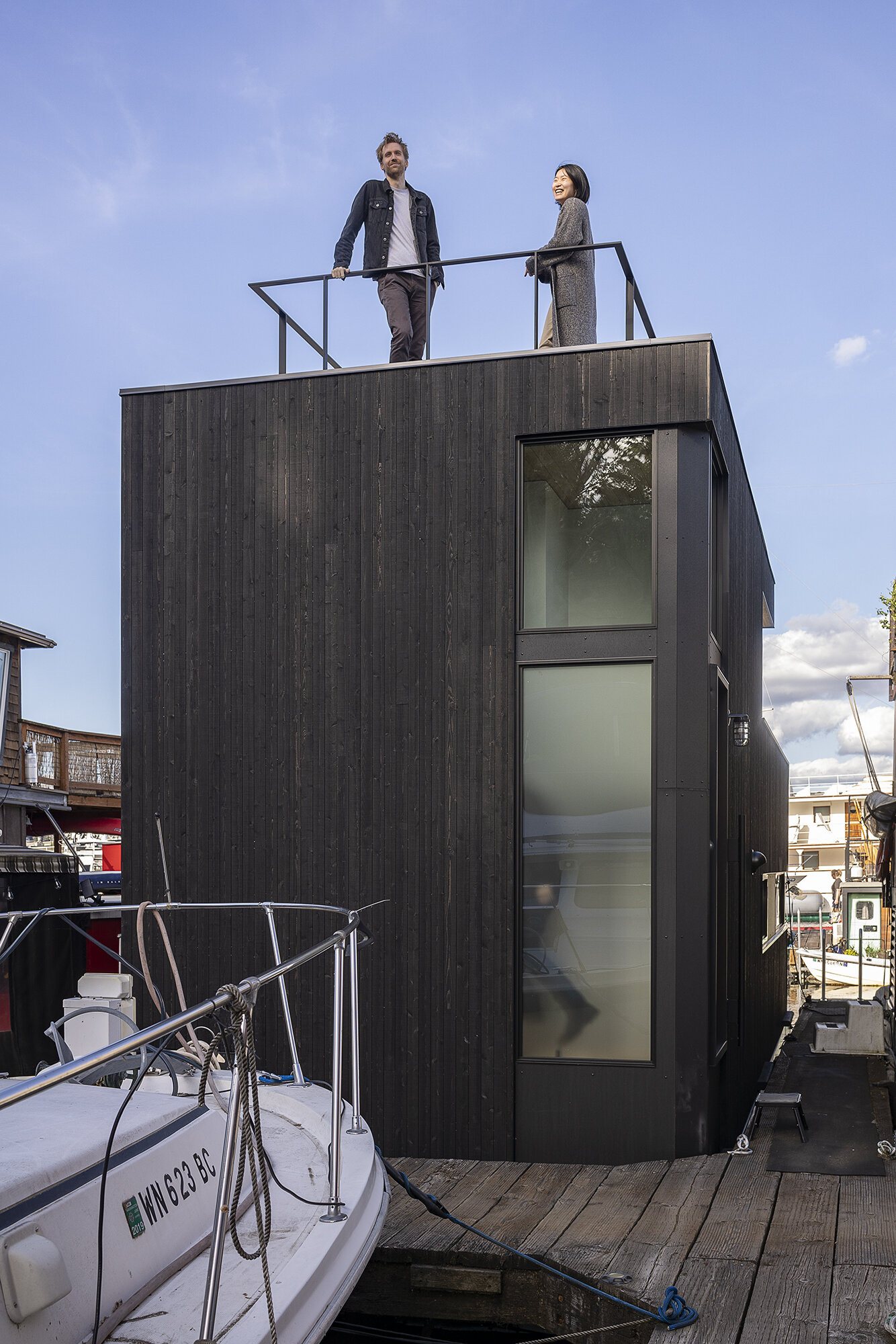 Vertical cedar siding, Richlite panels, and clear hemlock soffits give this floathome a refined, marine-ready exterior with architectural clarity.