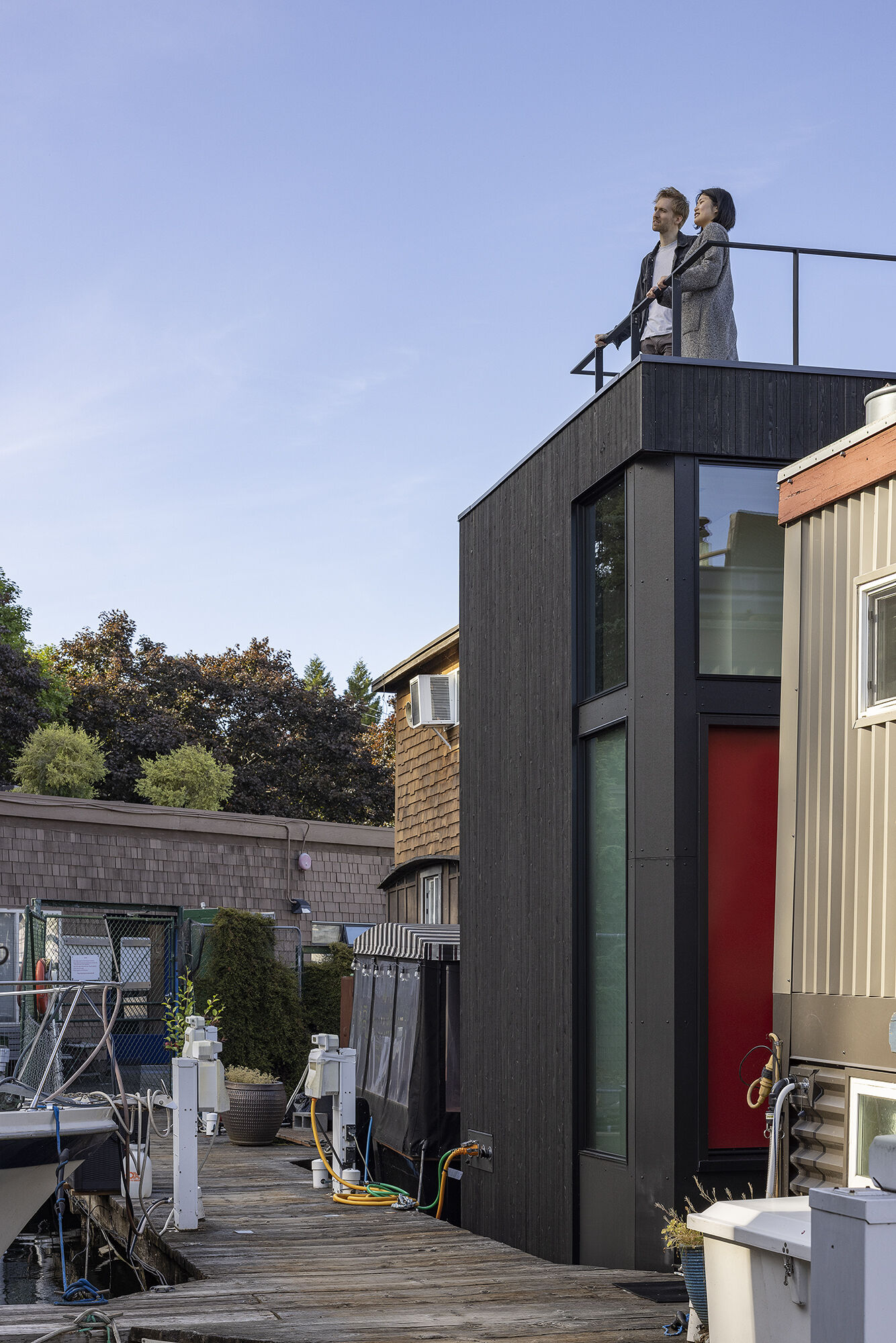 Vertical cedar siding, Richlite panels, and clear hemlock soffits give this floathome a refined, marine-ready exterior with architectural clarity.