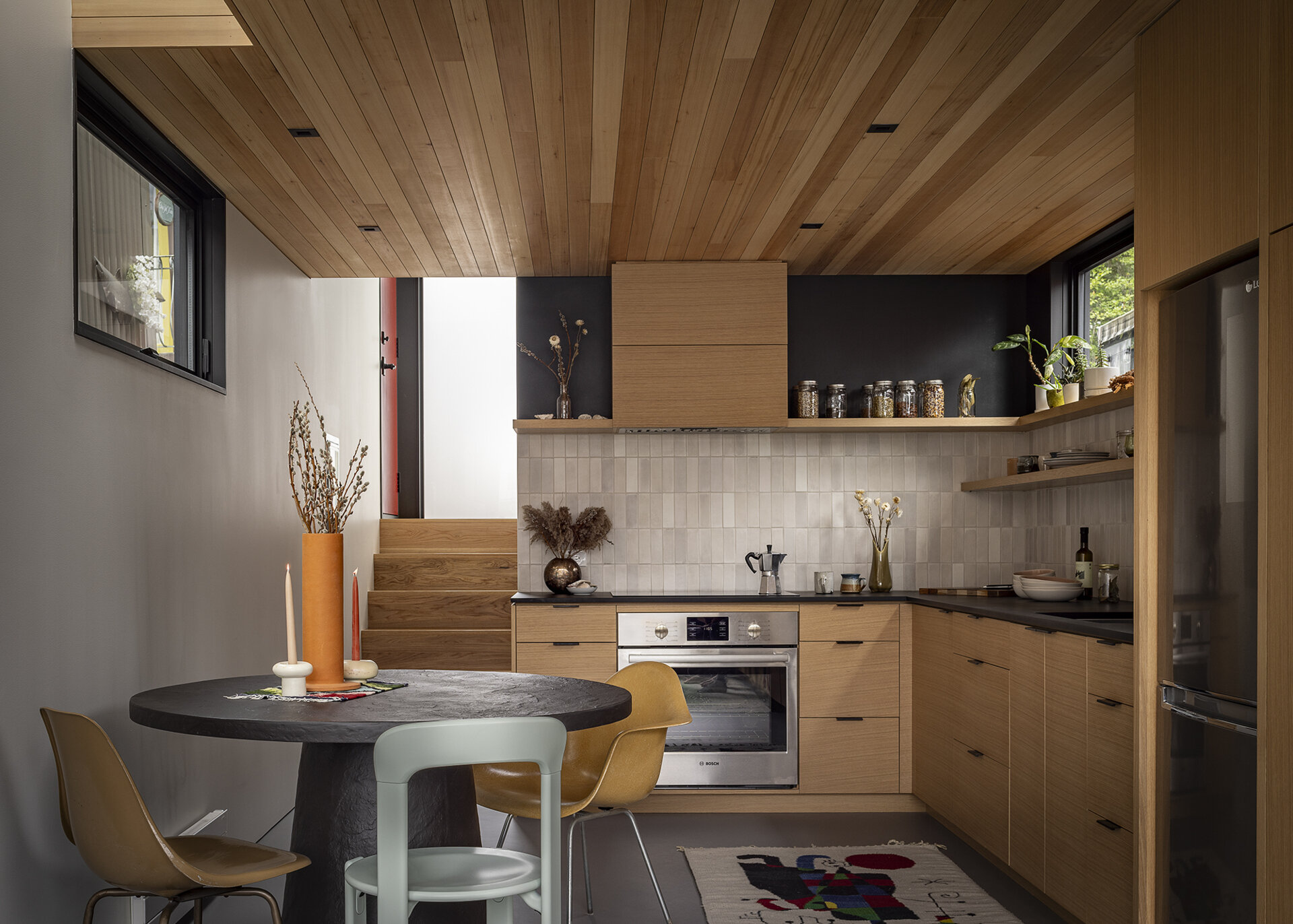 Inside the floathome, an L-shaped kitchen with custom oak cabinetry and a movable island delivers full-function cooking in a minimal space.