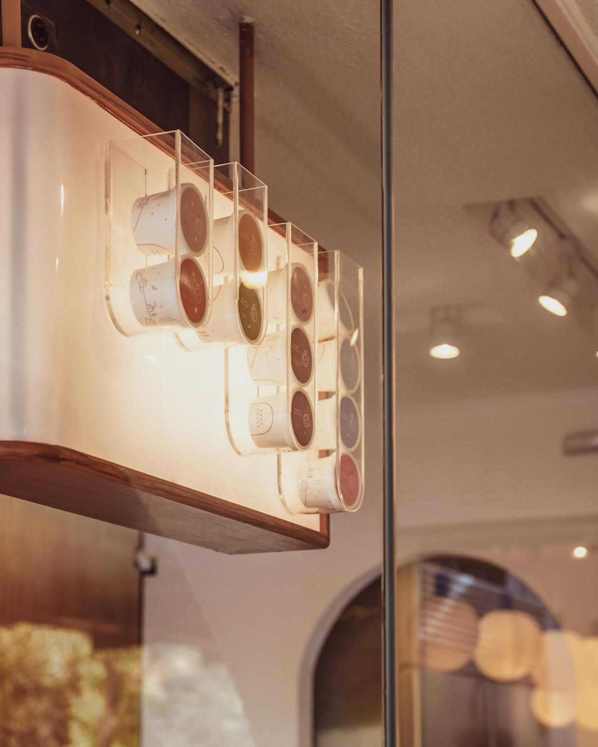 BEARHOUSE blends bubble tea and ice cream in a cozy café inspired by a bear cave and swirling ice cream textures. This small space uses soft two-tone colors and inviting built-in seating to create the perfect hangout.