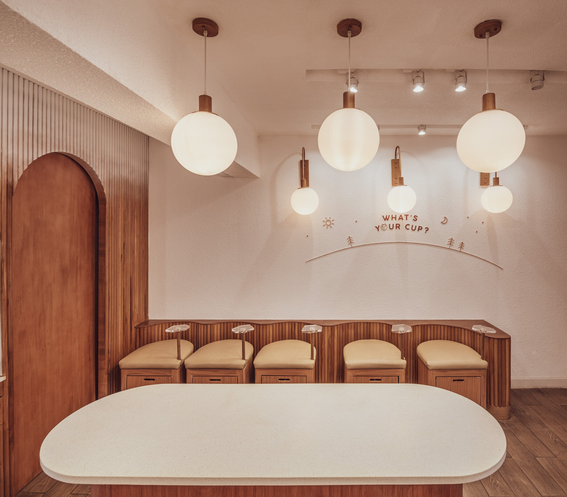 BEARHOUSE blends bubble tea and ice cream in a cozy café inspired by a bear cave and swirling ice cream textures. This small space uses soft two-tone colors and inviting built-in seating to create the perfect hangout.