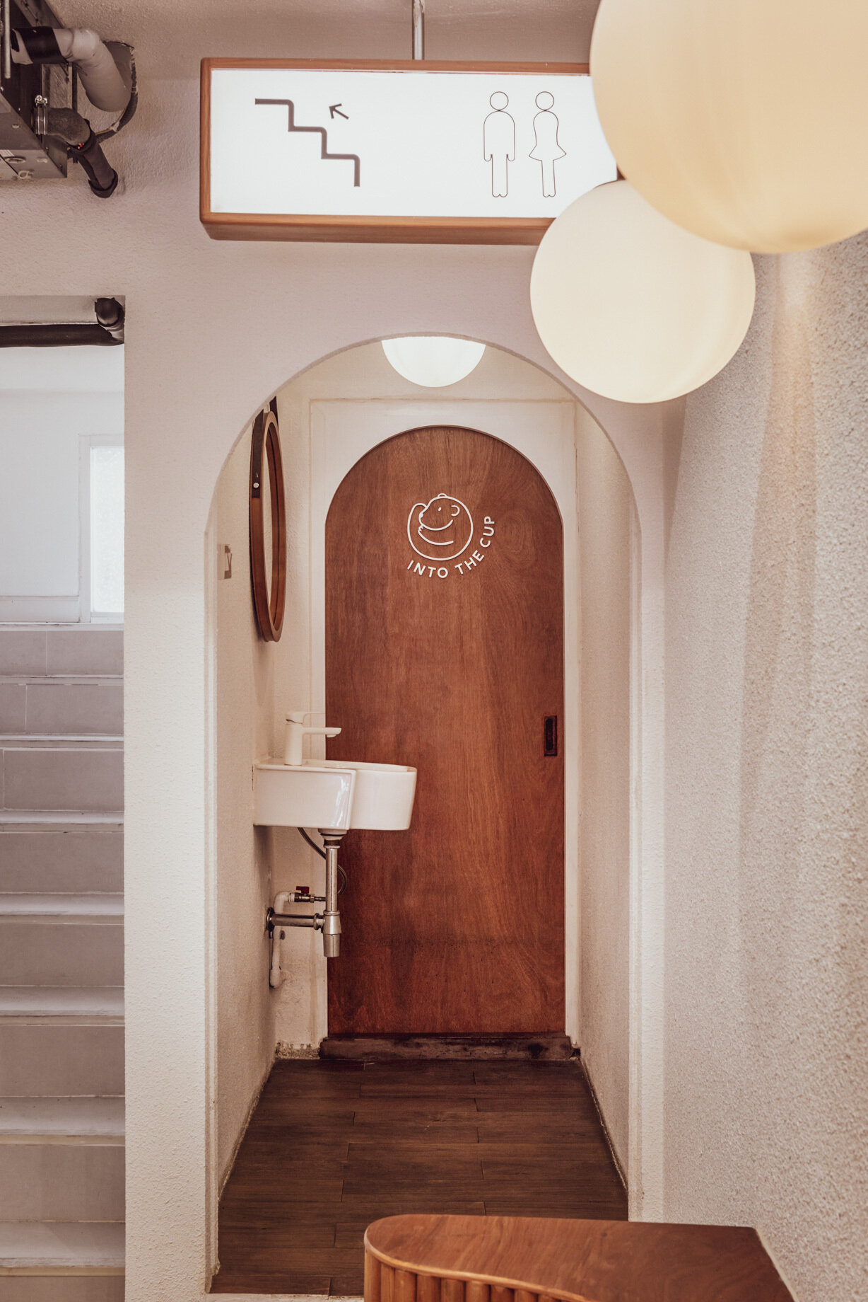 BEARHOUSE blends bubble tea and ice cream in a cozy café inspired by a bear cave and swirling ice cream textures. This small space uses soft two-tone colors and inviting built-in seating to create the perfect hangout.