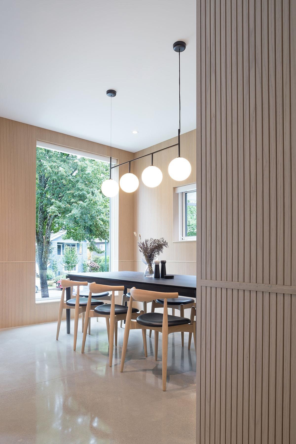 Wrapped in tambour oak veneer, this minimalist dining room is warm, textured, and softly lit, a perfect blend of Scandinavian influence and urban elegance.