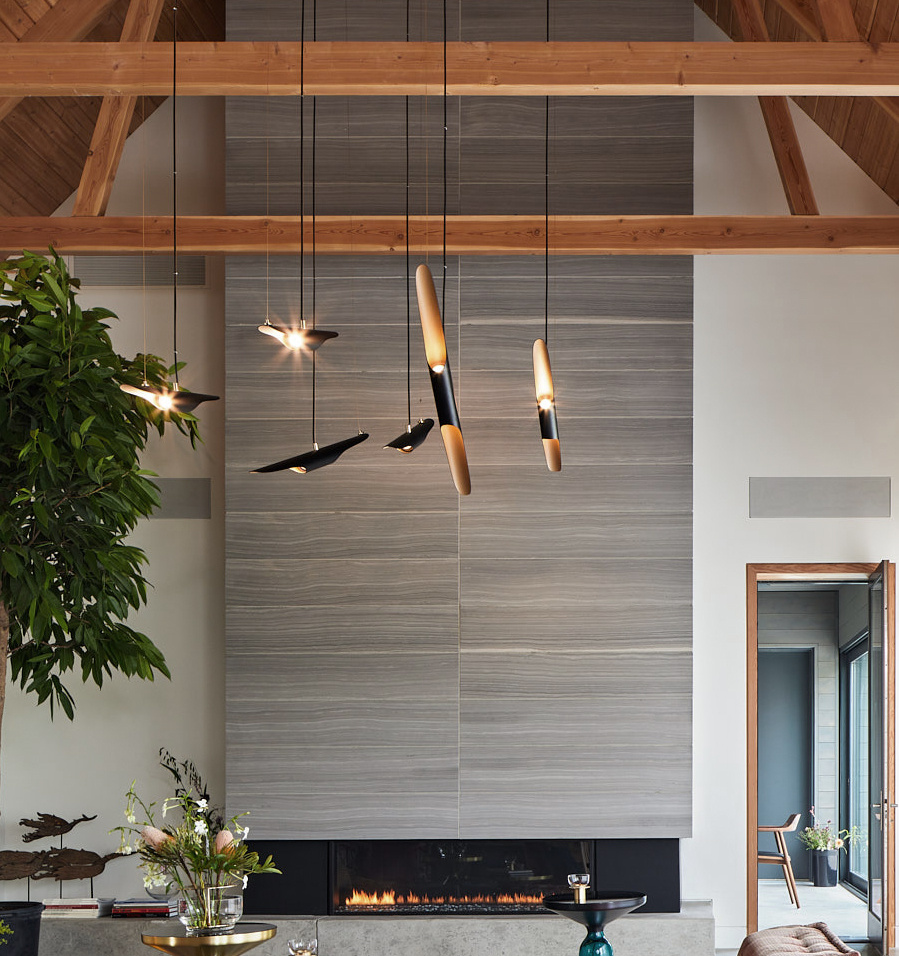 Warm minimalism defines this living room and kitchen, with a central fireplace, white oak finishes, and exposed Douglas fir beams.