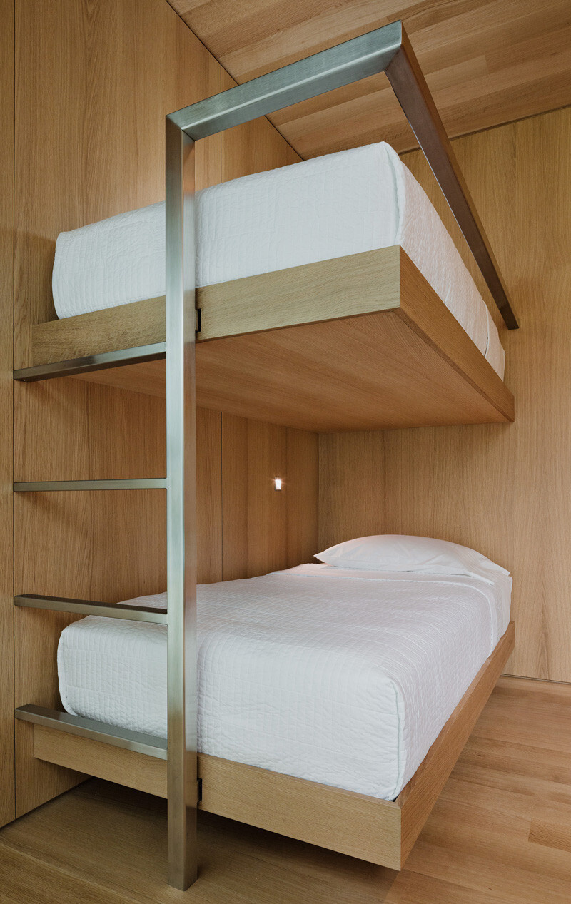 Built-in bunk bed nooks are tucked into the home’s central wood core, blending cozy sleeping space with natural light and airflow.