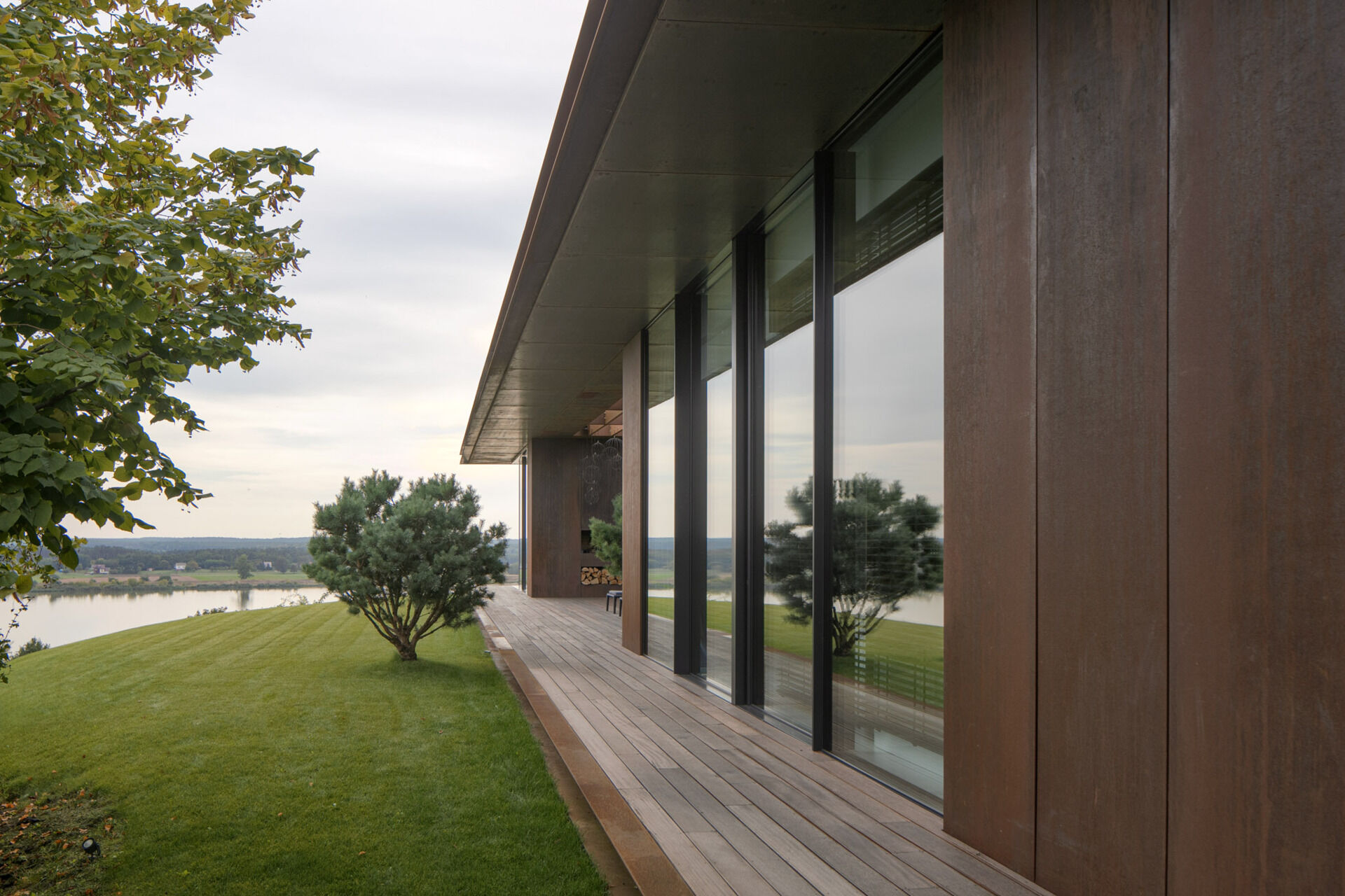 Large openings frame specific views of the river, slope, and vegetation. The 12-meter-wide sliding door in the living area allows the entire southeast wall to open up to the outdoors.