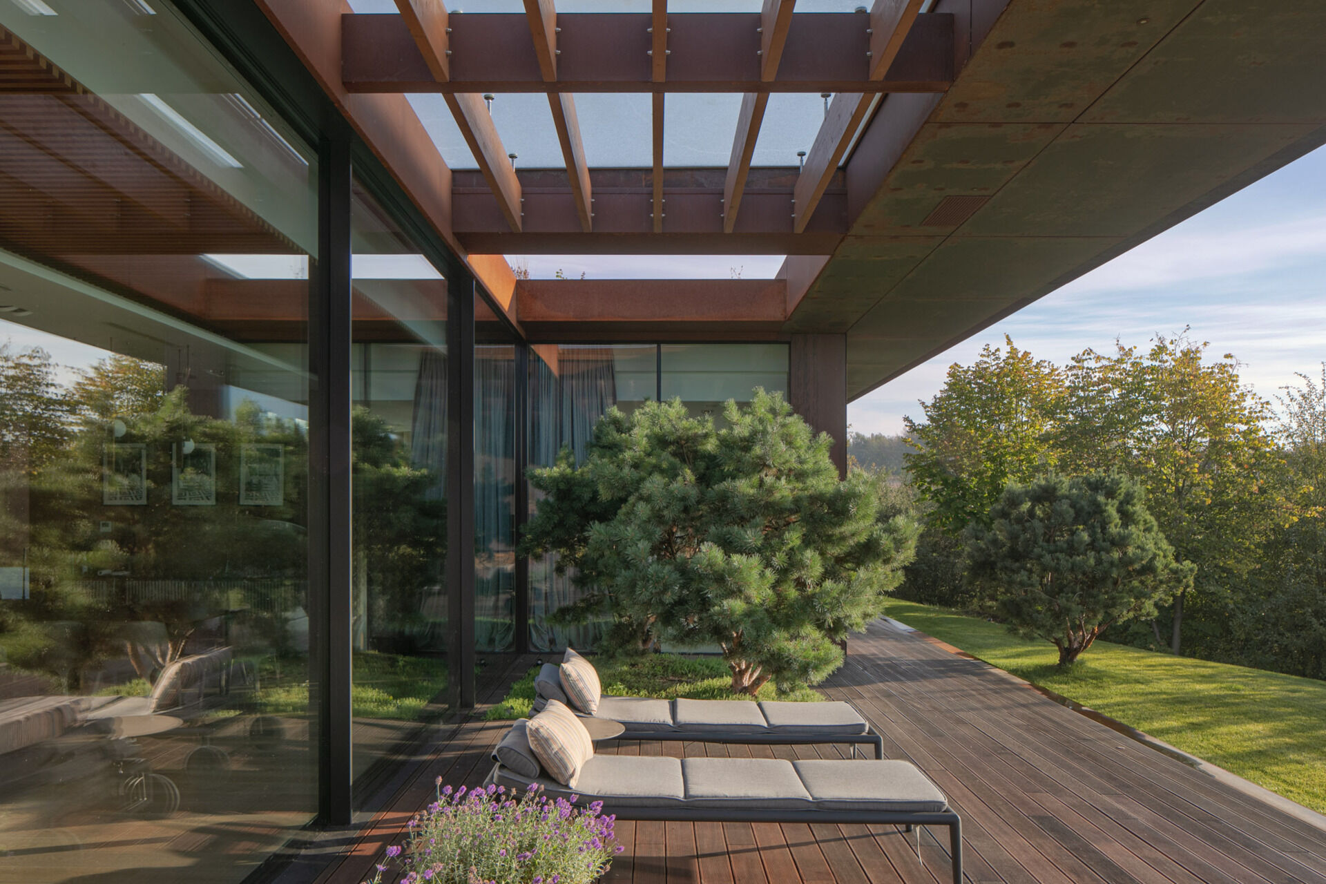 This modern home terrace extends directly from the main living space and faces the river. It's positioned for sunlight and views without elevation, continuing the natural incline of the site. It acts as a threshold between interior and landscape, not a platform above it, but a surface within it.