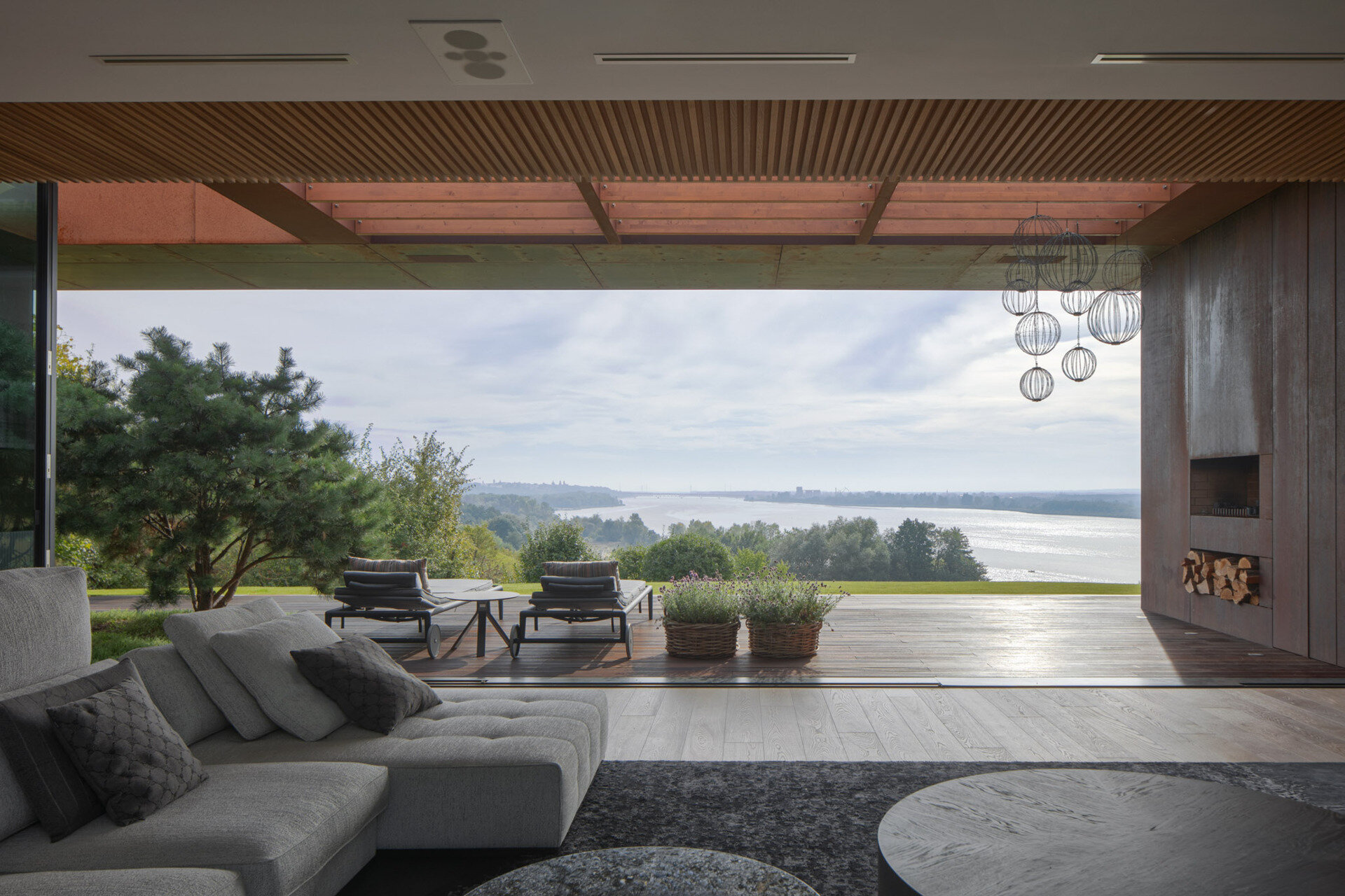 This modern home terrace extends directly from the main living space and faces the river. It's positioned for sunlight and views without elevation, continuing the natural incline of the site. It acts as a threshold between interior and landscape, not a platform above it, but a surface within it.