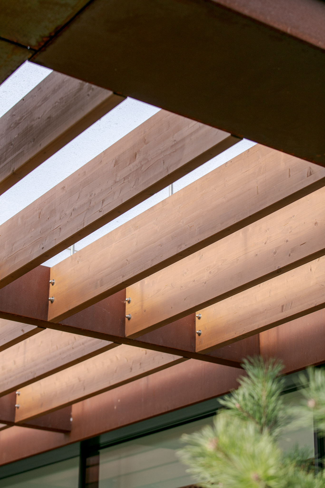 This modern home terrace extends directly from the main living space and faces the river. It's positioned for sunlight and views without elevation, continuing the natural incline of the site. It acts as a threshold between interior and landscape, not a platform above it, but a surface within it.