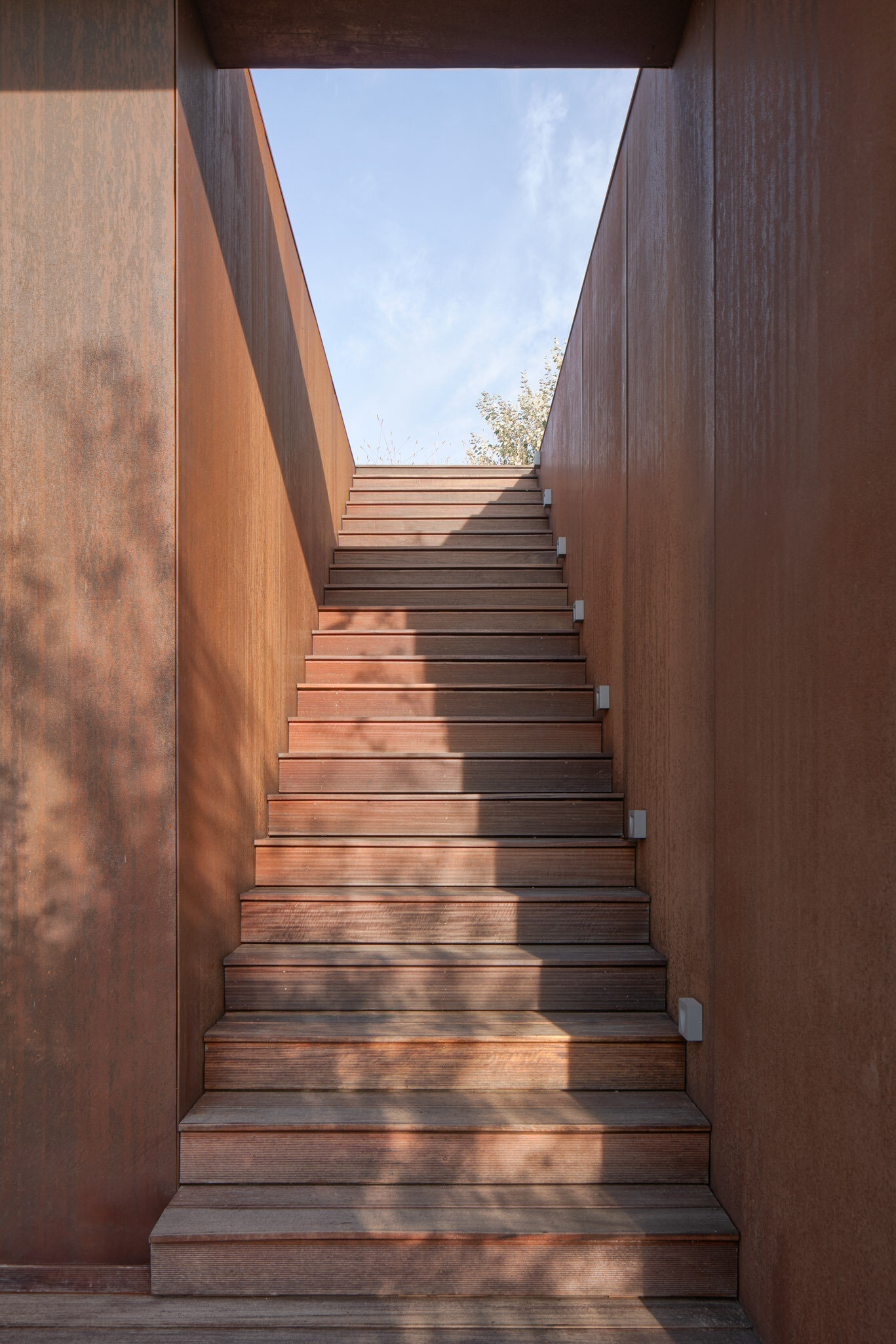 A discreet set of stairs leads up to the rooftop, inviting residents to fully experience the green roof as an extension of the landscape.
