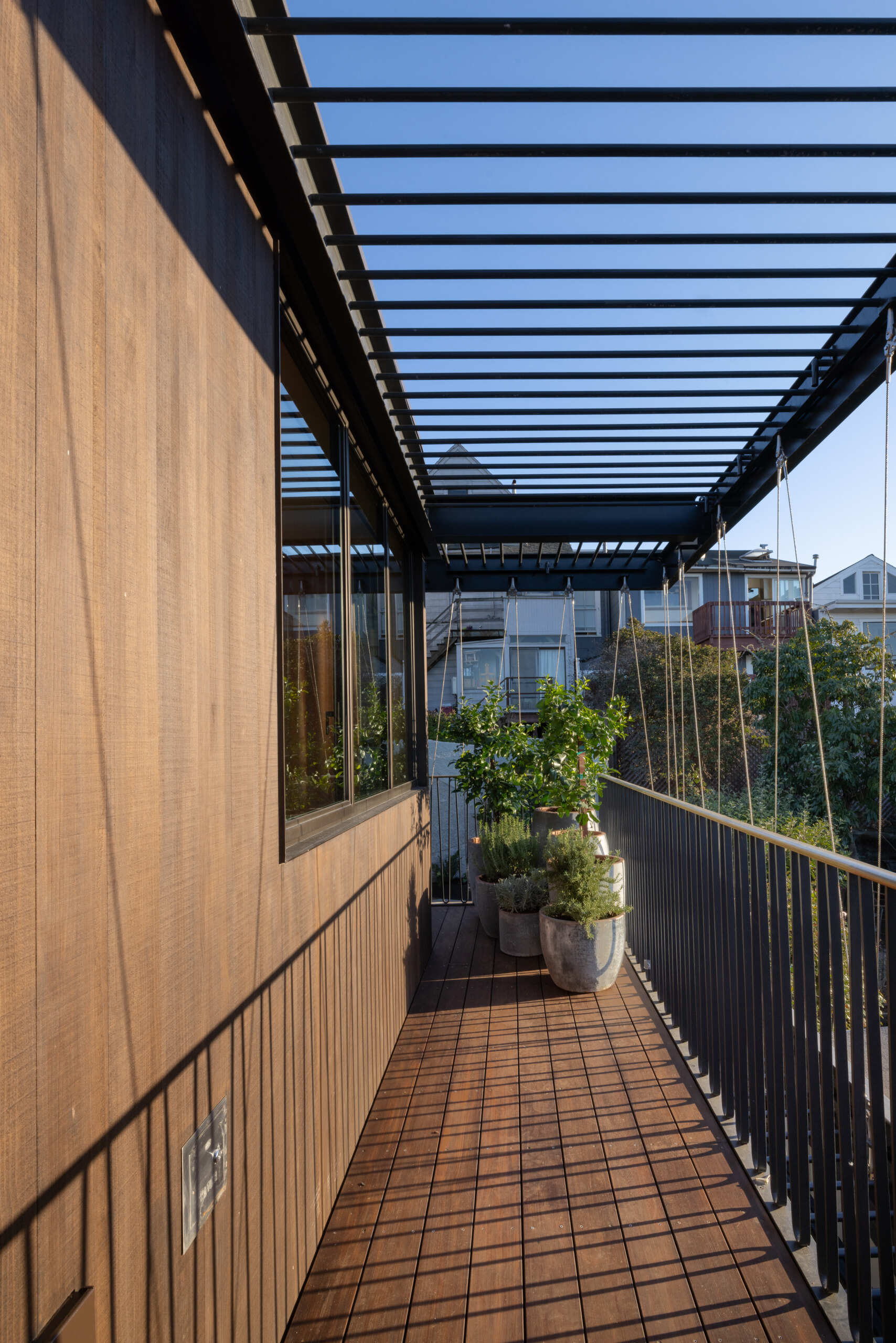 At the back, the home connects effortlessly to the garden. Natural light spills in through generous glazing, while solid stone slabs help visually anchor the indoor-outdoor flow. It is a rear facade that does not just face the backyard, it becomes part of it.
