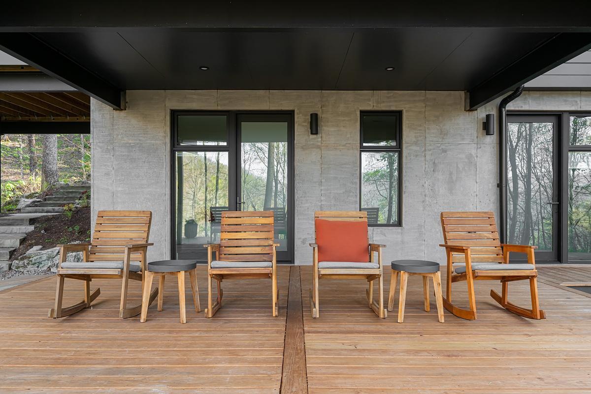The covered deck off the basement volume faces the creek and serves as a quiet outdoor refuge.