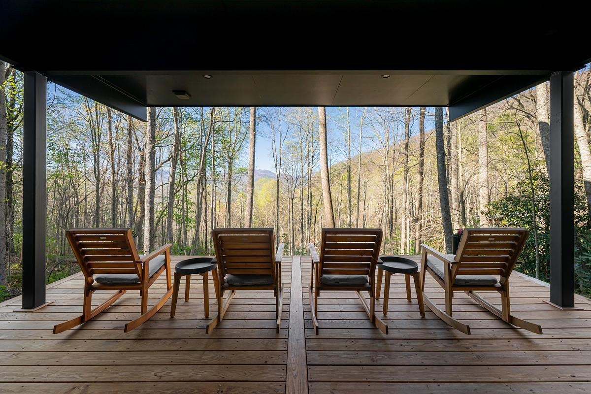 The covered deck off the basement volume faces the creek and serves as a quiet outdoor refuge.