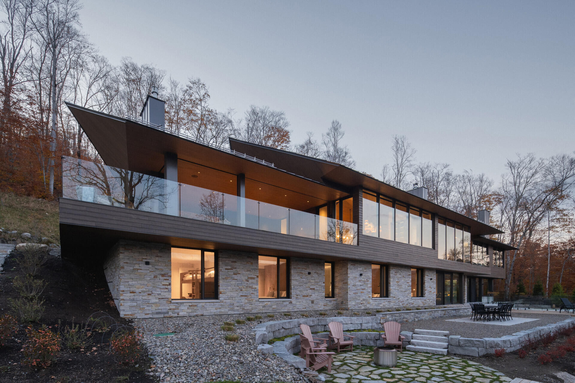 A striking modern chalet by MU Architecture, La Flèche is a forest retreat on Lake Tremblant that blends sharp rooflines, natural stone, and warm wood interiors.