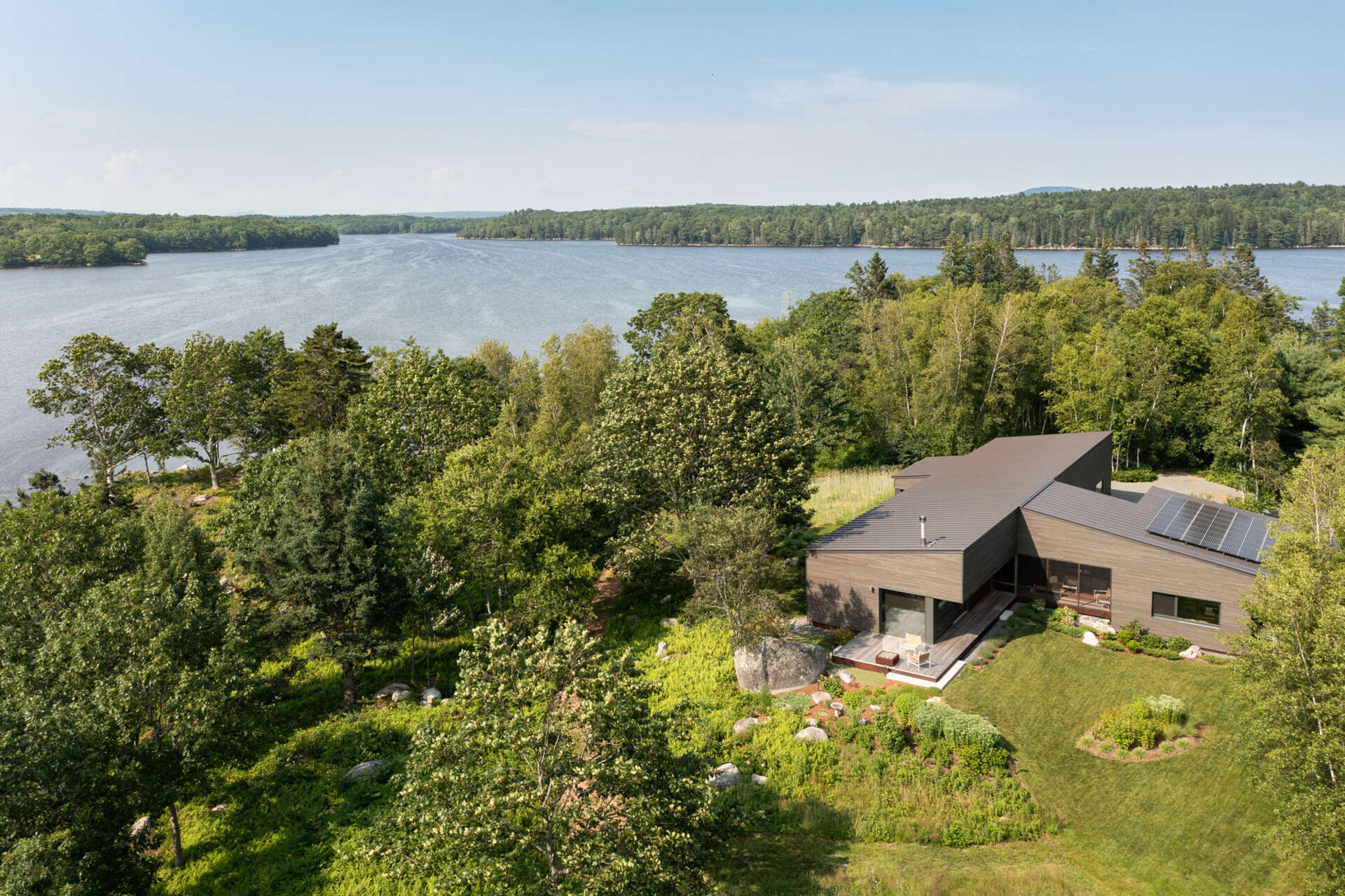 This Maine home unites workshop, garage, and living spaces under one simple gabled roof, with smart transitions and passive solar design woven into every detail.
