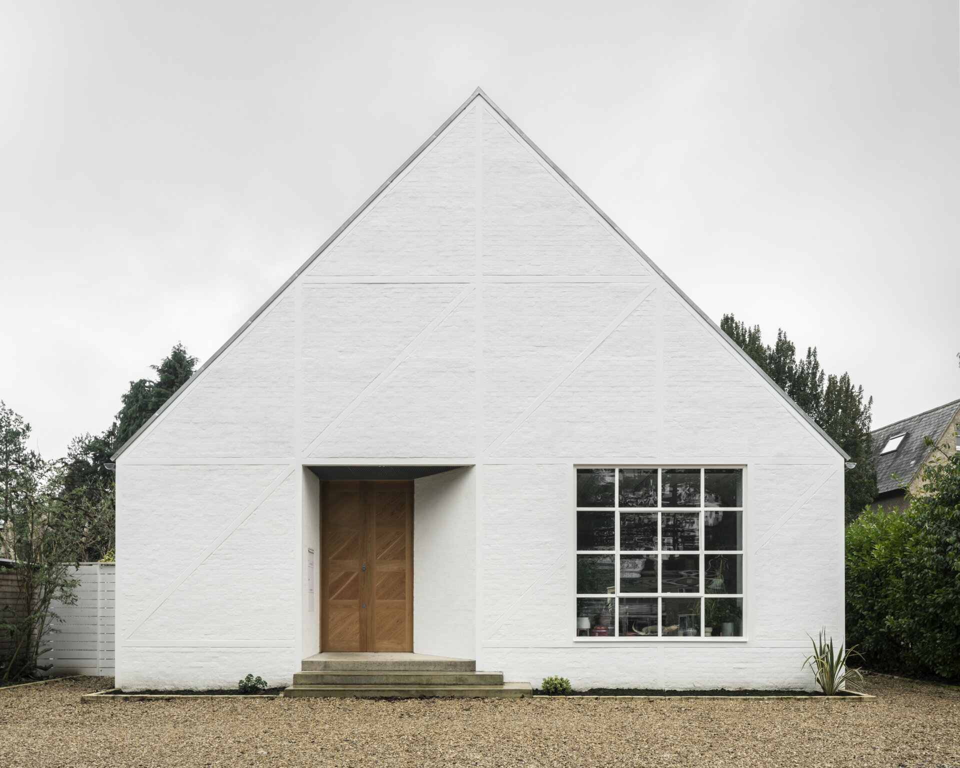 With its pitched roof, steel exoskeleton, and slurried brick infill, this London home borrows from suburban mock-Tudor while turning the style completely on its head.