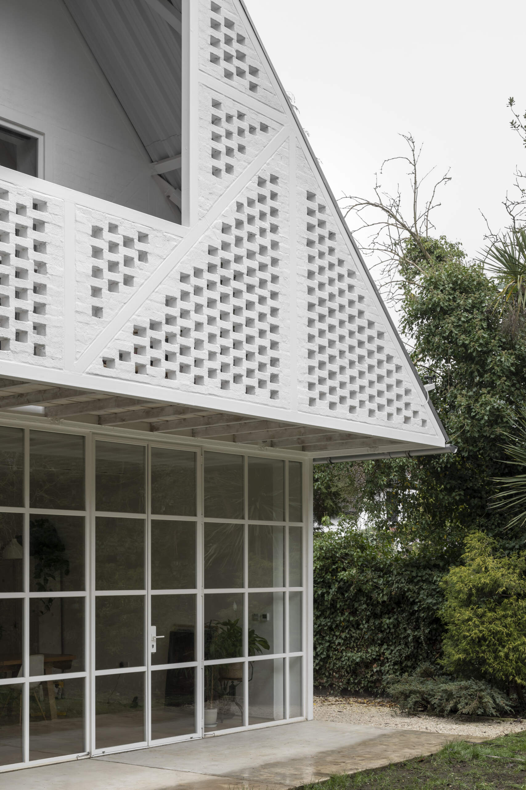 With its pitched roof, steel exoskeleton, and slurried brick infill, this London home borrows from suburban mock-Tudor while turning the style completely on its head.