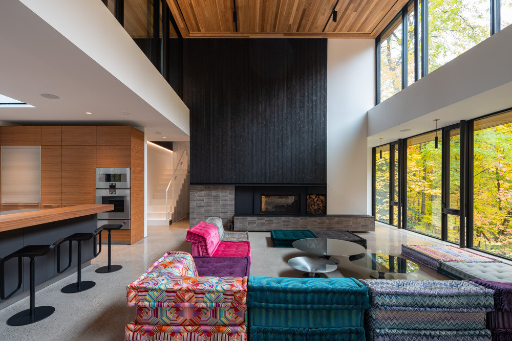 An open-plan living area with a colorful couch, relocated fireplace, generous daylight, and seamless flow.