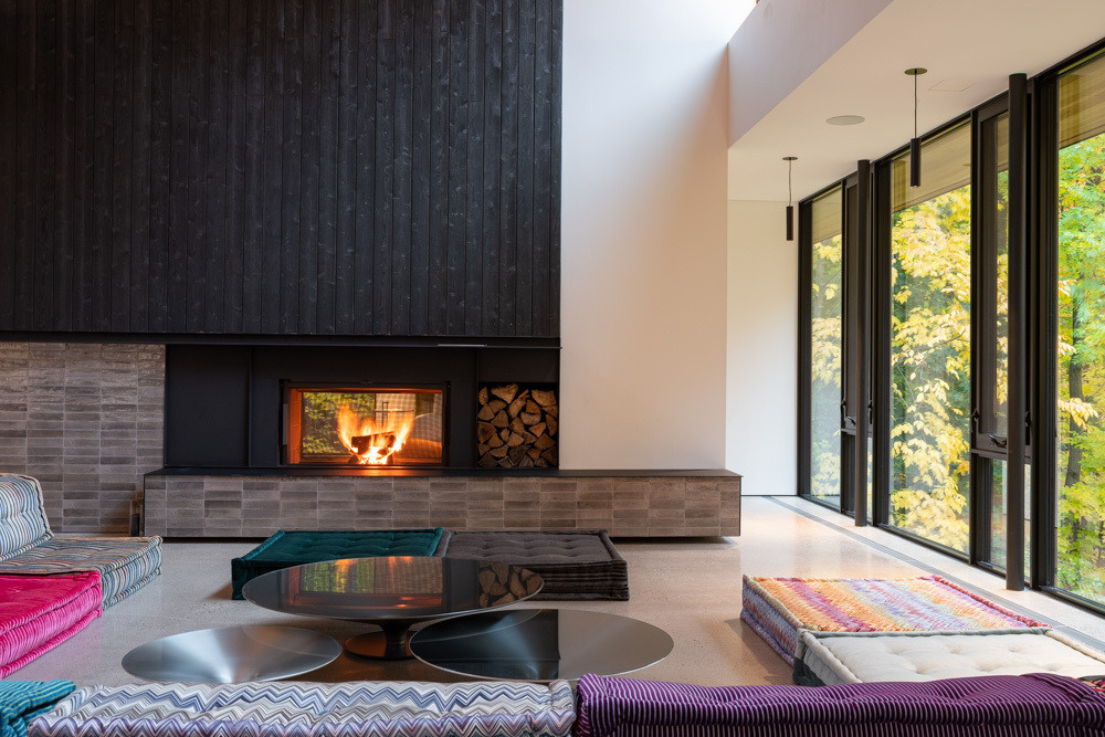 An open-plan living area with a colorful couch, relocated fireplace, generous daylight, and seamless flow.