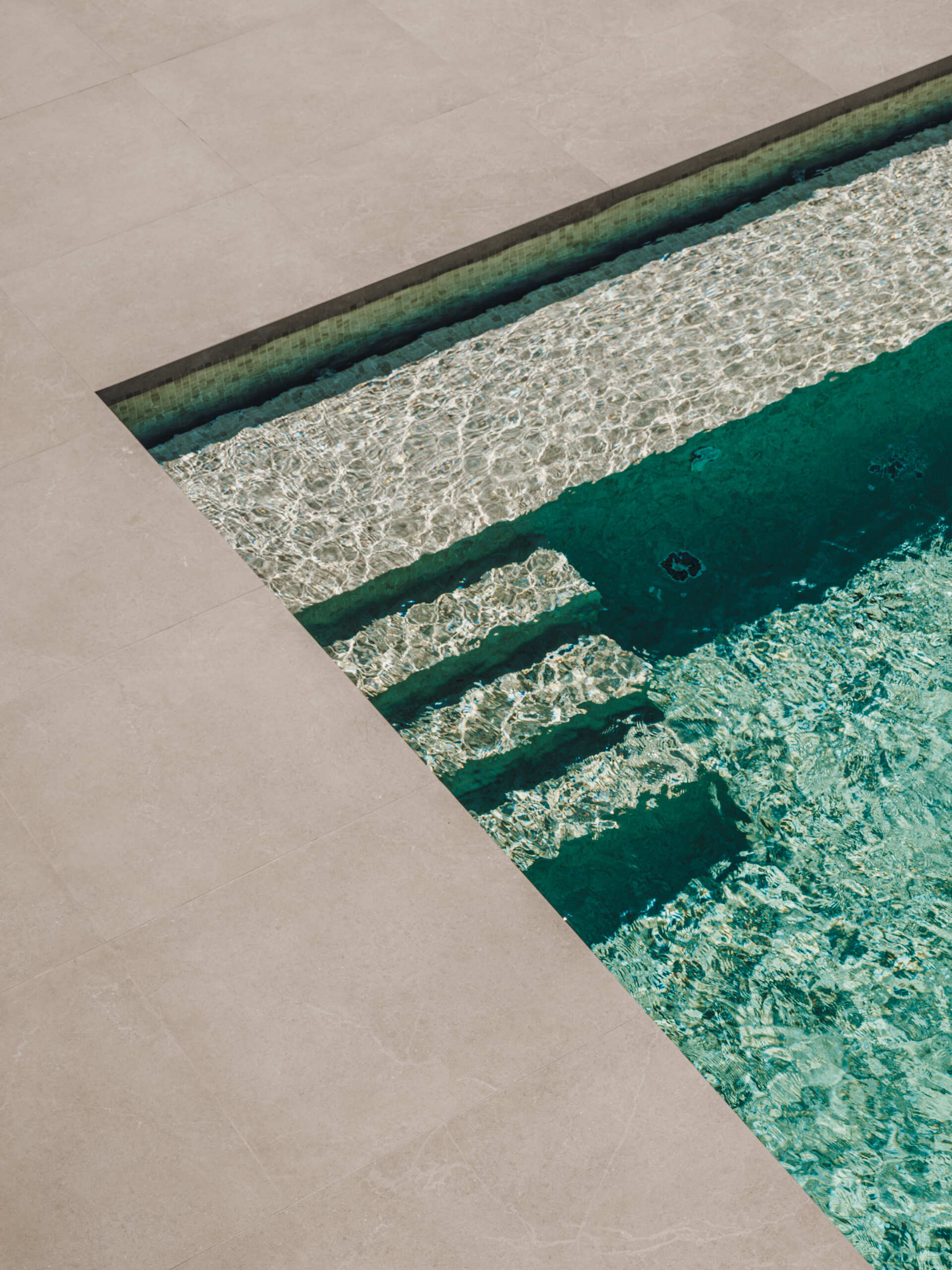 A 36 sqm pool extends from the travertine terrace, echoing the home's clean lines and seamless indoor-outdoor connection.