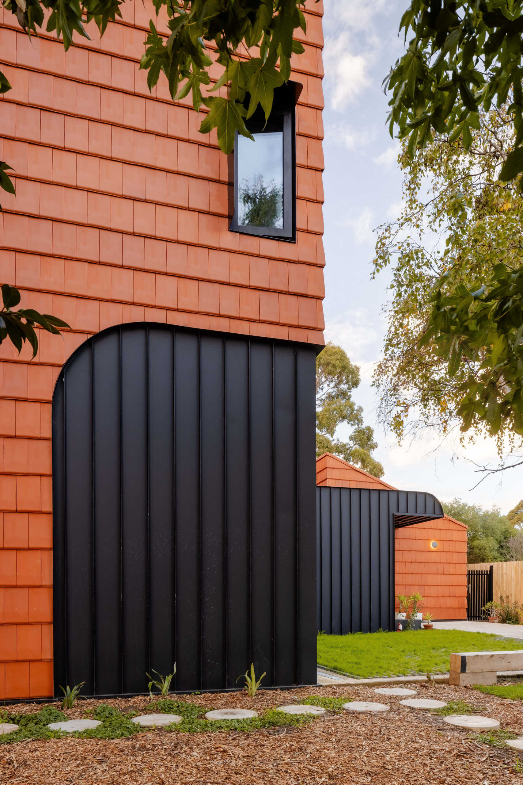 Discover how this Melbourne home uses terracotta shingles on both roof and walls, blending sustainable materials with a warm, natural palette rooted in the surrounding trees.