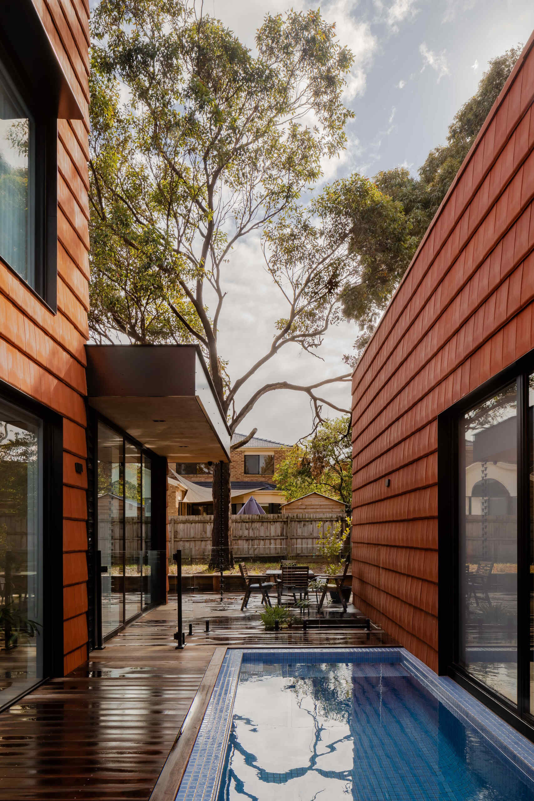 A central courtyard pool becomes the heart of the home, offering a calm, private oasis framed by living spaces and mature trees.