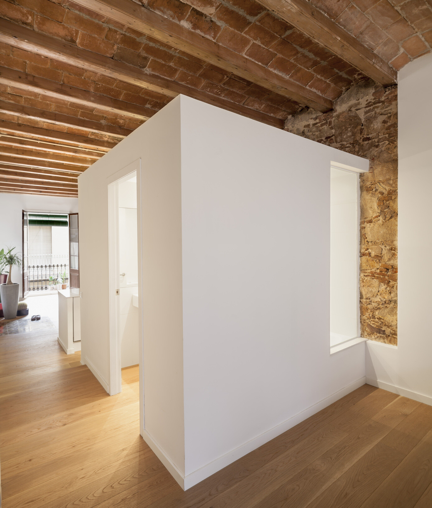 A serene, Japanese-inspired Barcelona apartment that blends stone walls, natural oak, soft light, and open-plan living.