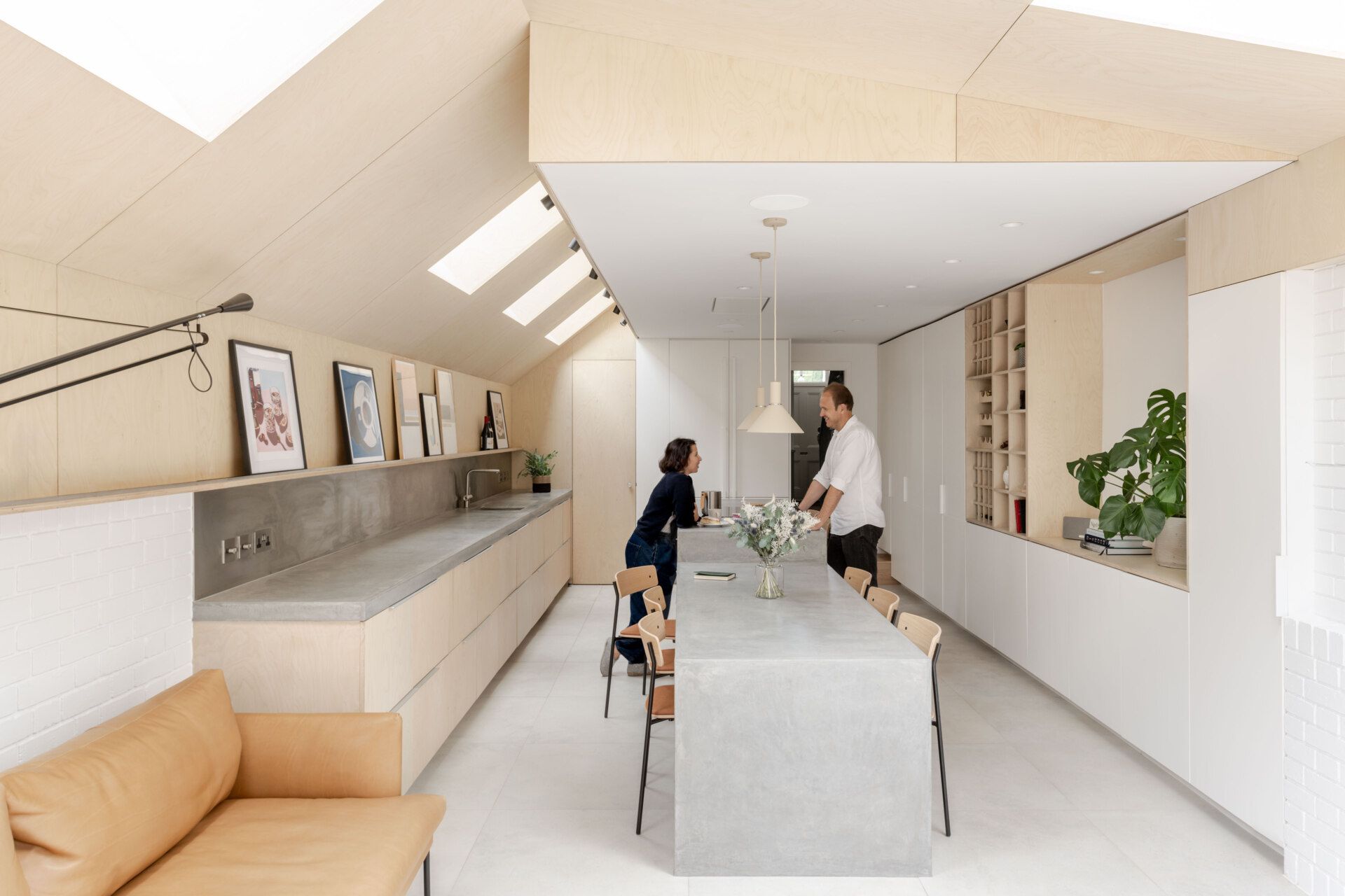 Custom birch plywood cabinetry and soft concrete tones bring a quiet Scandinavian feel to this highly functional kitchen. A 6-metre-long cast concrete island acts as both prep space and dining table, sculptural, refined, and built for entertaining.