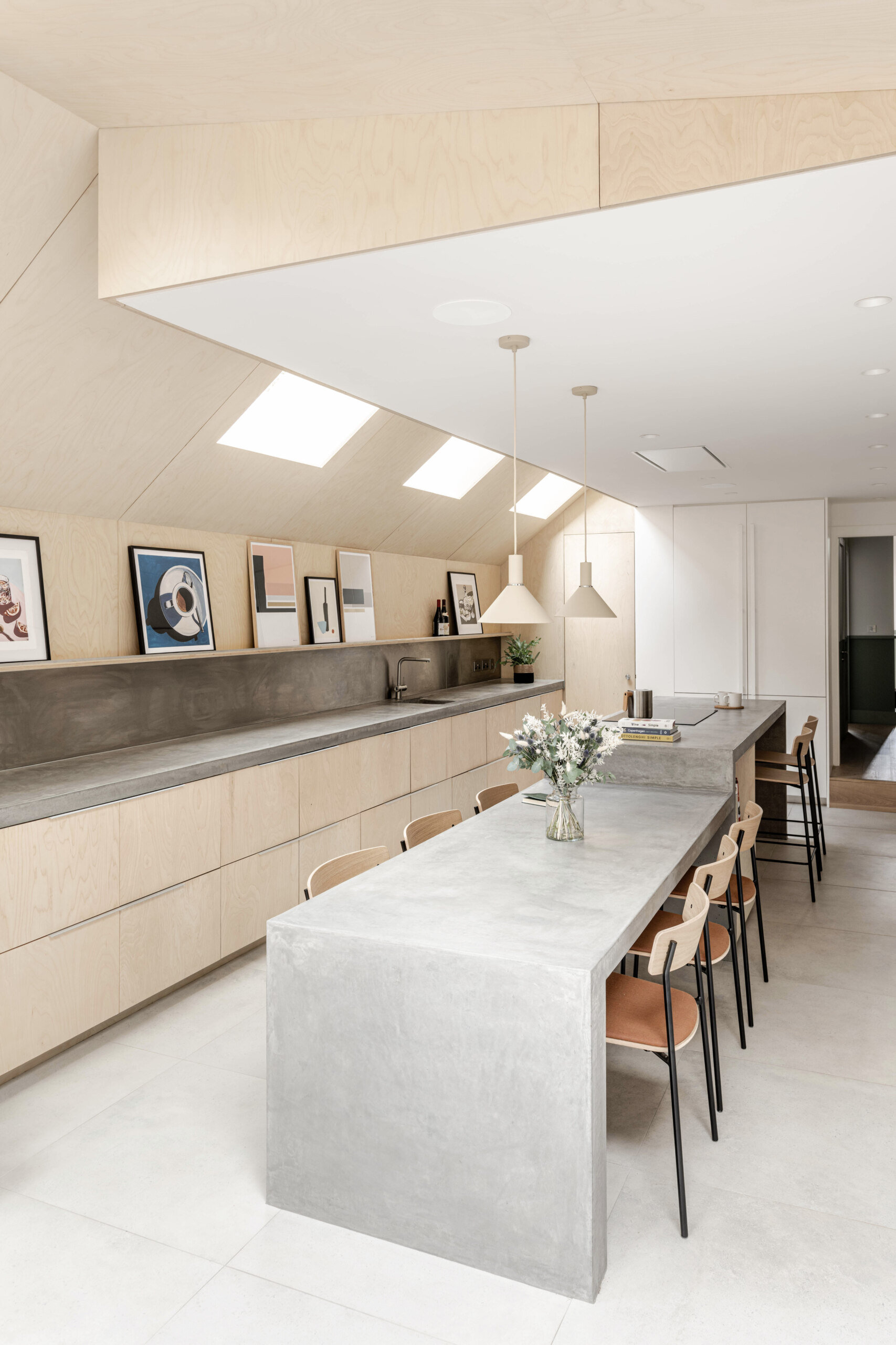 Custom birch plywood cabinetry and soft concrete tones bring a quiet Scandinavian feel to this highly functional kitchen. A 6-metre-long cast concrete island acts as both prep space and dining table, sculptural, refined, and built for entertaining.
