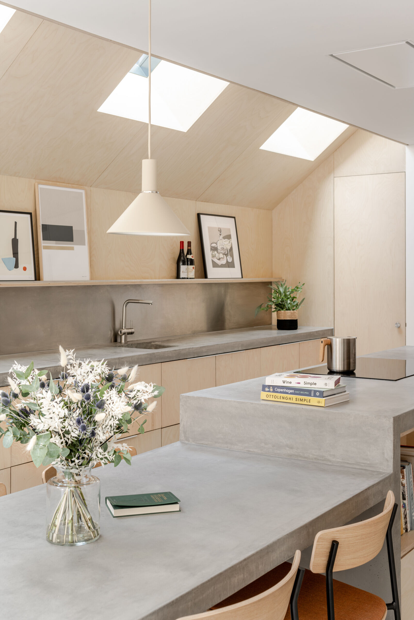 Custom birch plywood cabinetry and soft concrete tones bring a quiet Scandinavian feel to this highly functional kitchen. A 6-metre-long cast concrete island acts as both prep space and dining table, sculptural, refined, and built for entertaining.
