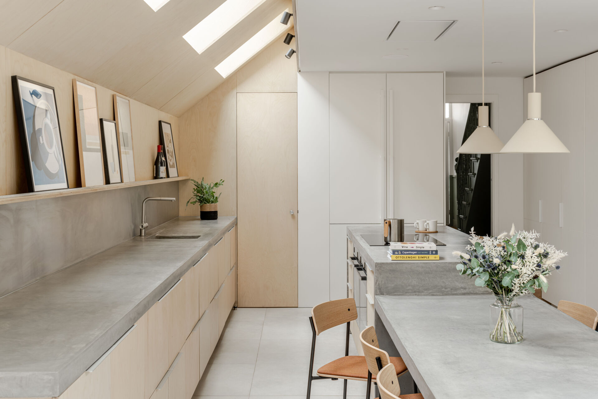 Custom birch plywood cabinetry and soft concrete tones bring a quiet Scandinavian feel to this highly functional kitchen. A 6-metre-long cast concrete island acts as both prep space and dining table, sculptural, refined, and built for entertaining.