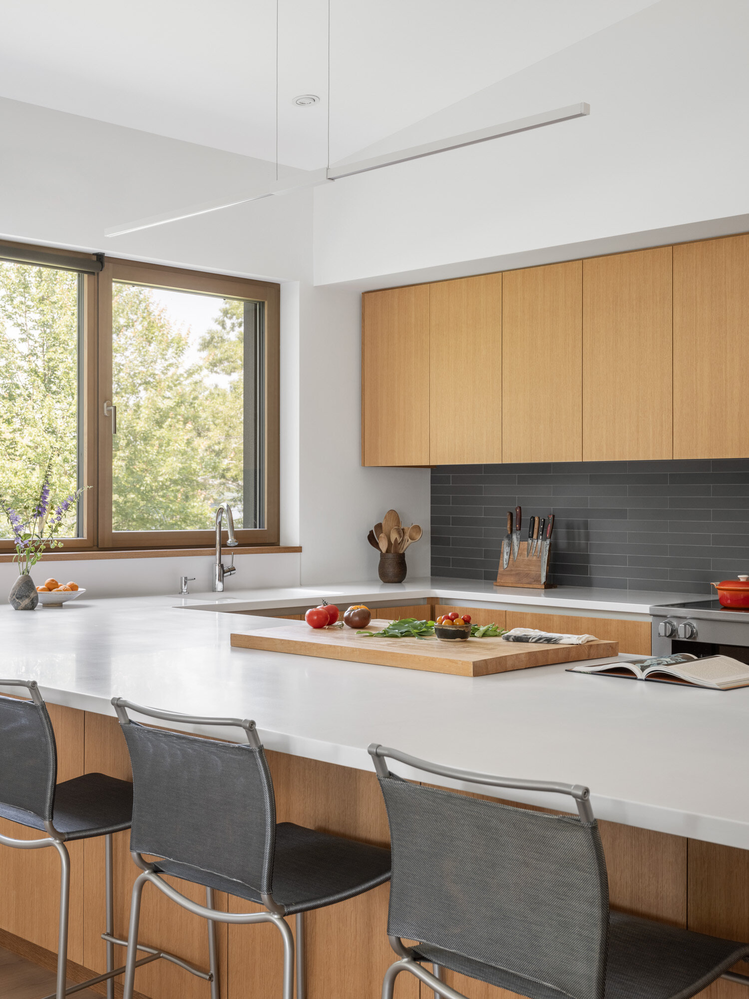 A minimalist kitchen in white oak feels calm and connected, flowing easily into the rest of the home without interrupting the view.