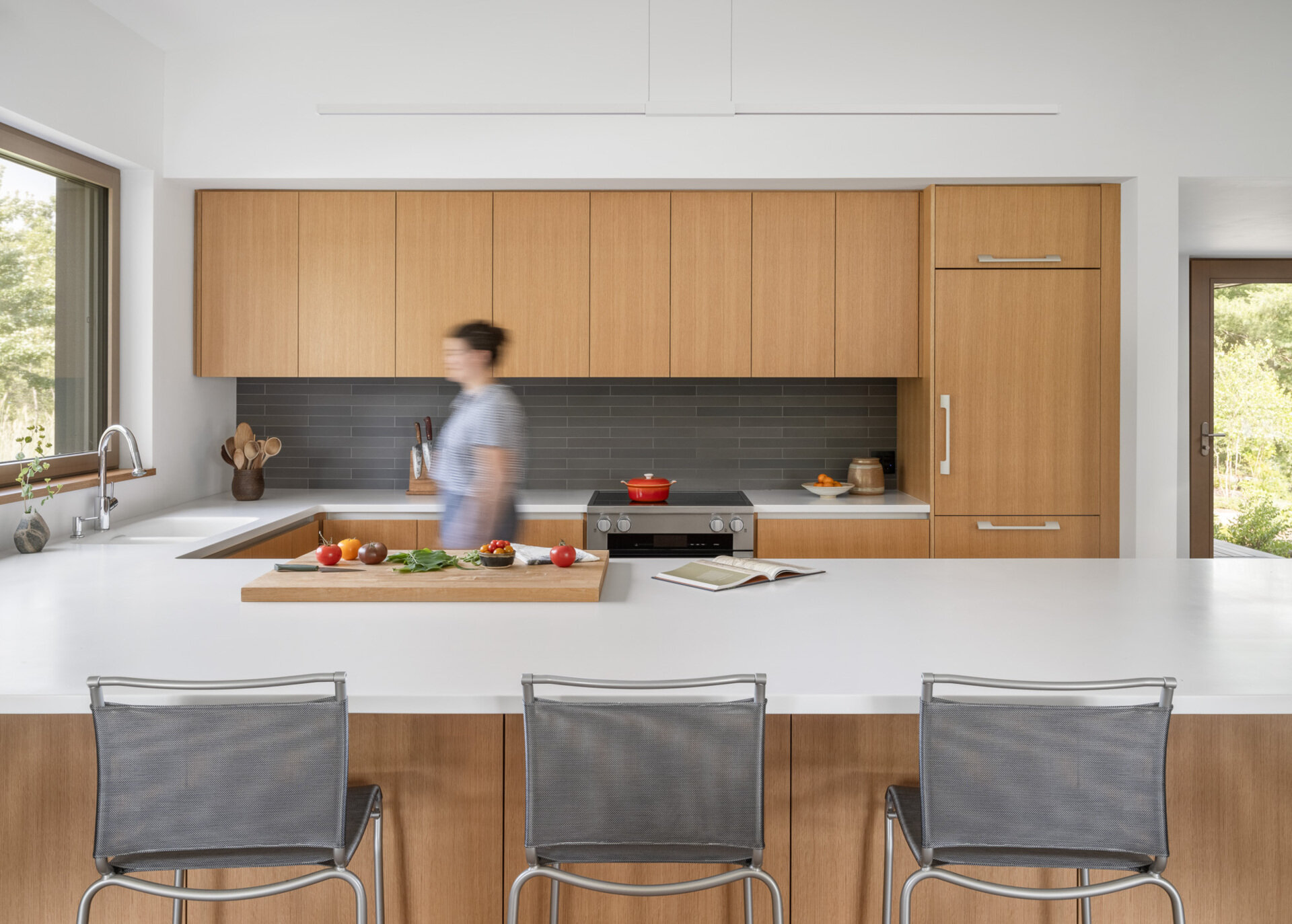 A minimalist kitchen in white oak feels calm and connected, flowing easily into the rest of the home without interrupting the view.