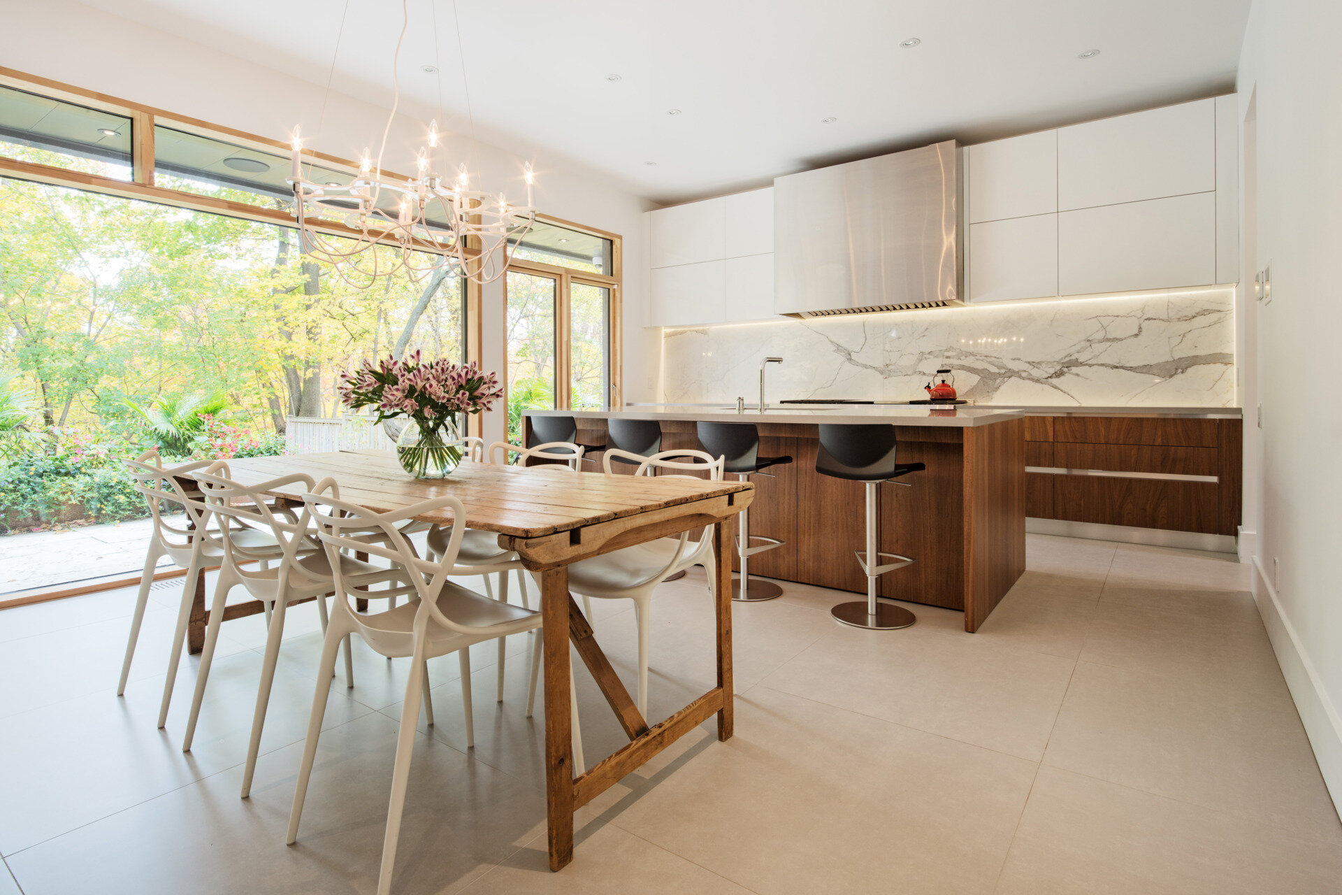 A warm wood accent wall anchors the family room in this open-concept main floor. With a wood dining table and seamless flow into the kitchen, the space feels both grounded and connected.