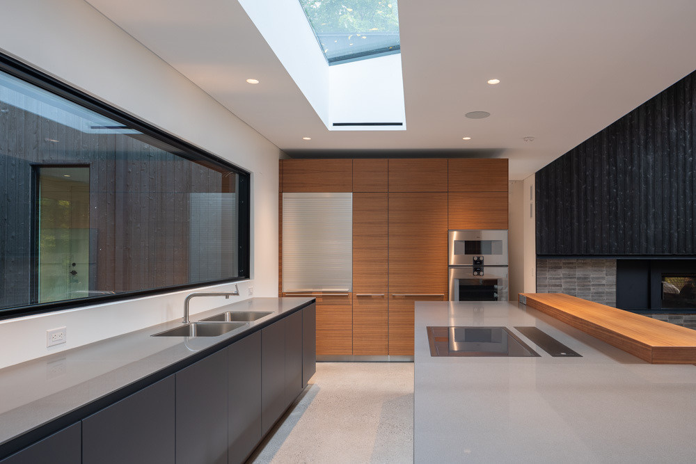 Sleek cabinetry, warm wood accents, and skylit ceilings define this modern kitchen.
