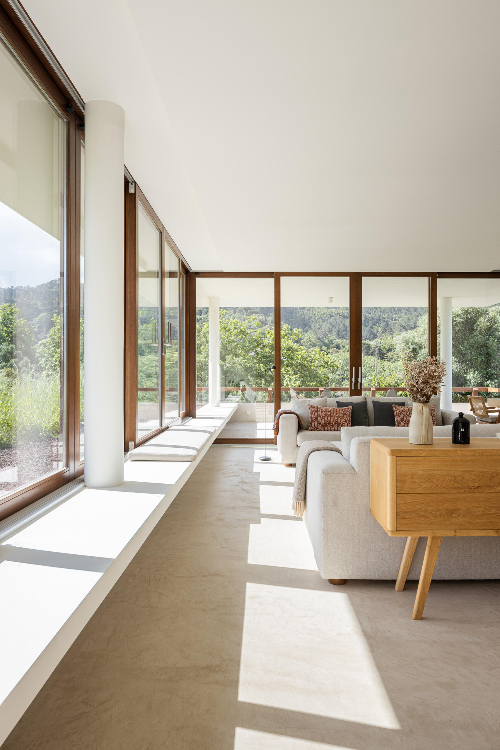Large sliding glass panels blur the boundary between inside and out, turning the ever-changing landscape into a living backdrop, while a fireplace in the living room adds warmth to the space.