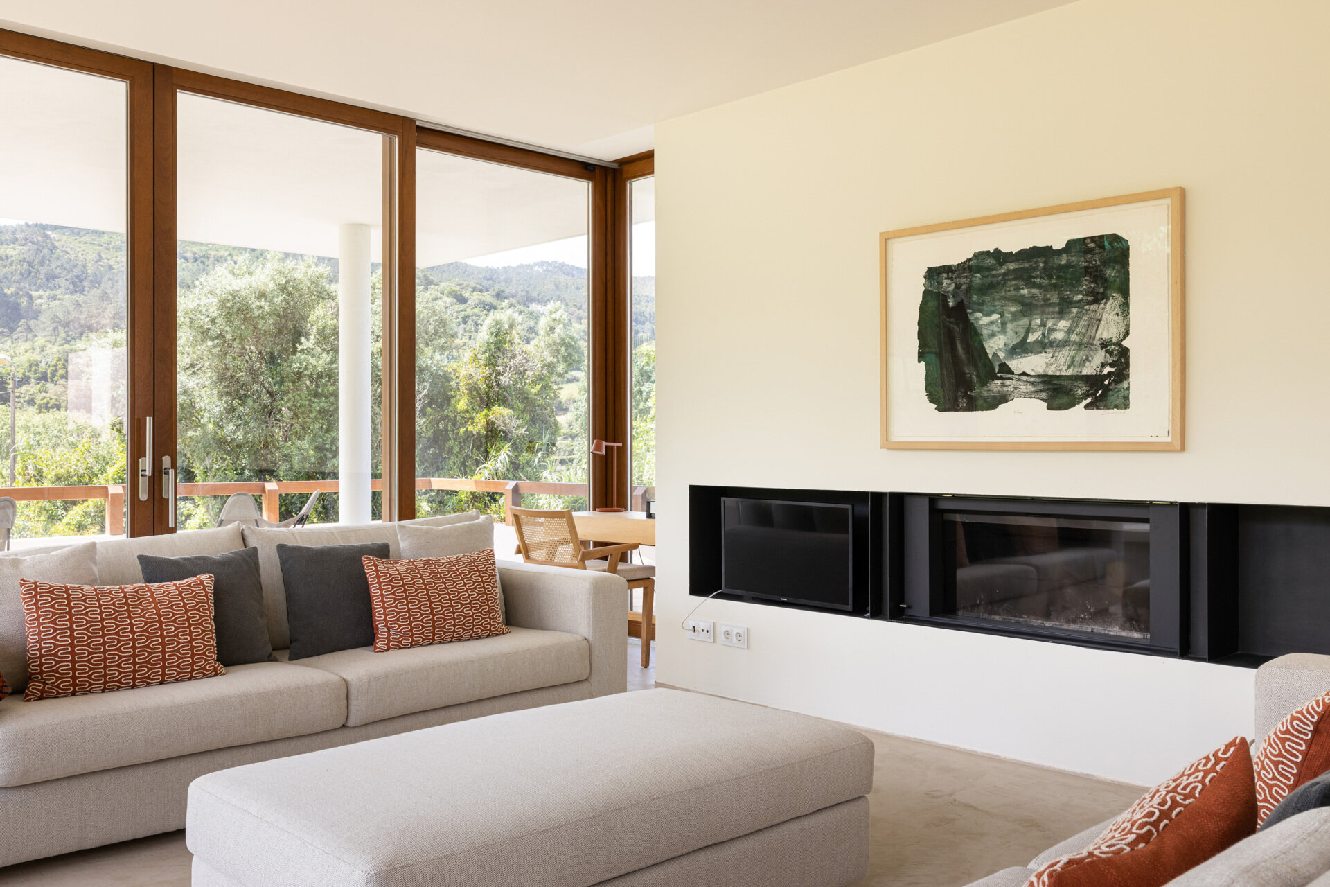 Large sliding glass panels blur the boundary between inside and out, turning the ever-changing landscape into a living backdrop, while a fireplace in the living room adds warmth to the space.