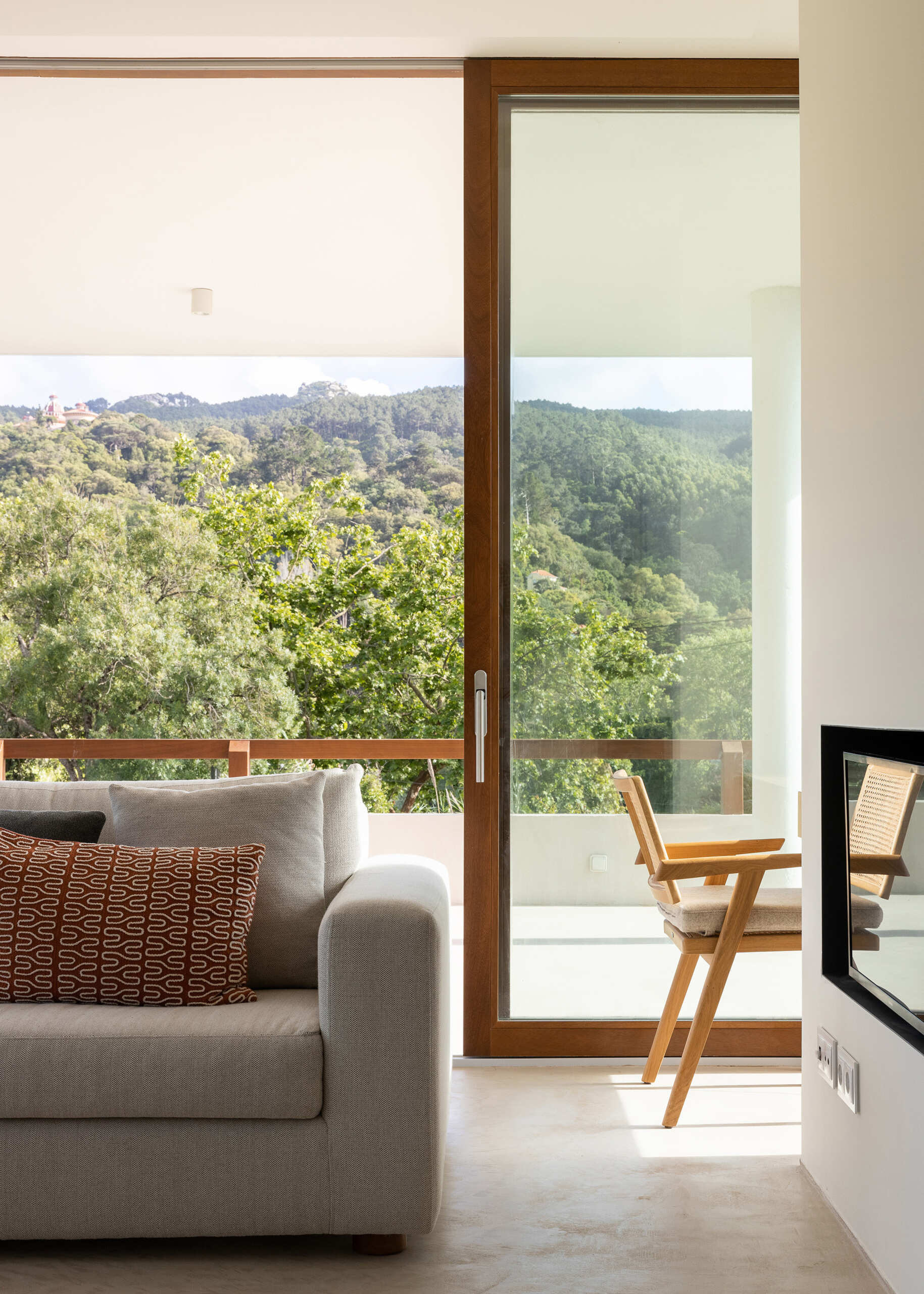 Large sliding glass panels blur the boundary between inside and out, turning the ever-changing landscape into a living backdrop, while a fireplace in the living room adds warmth to the space.