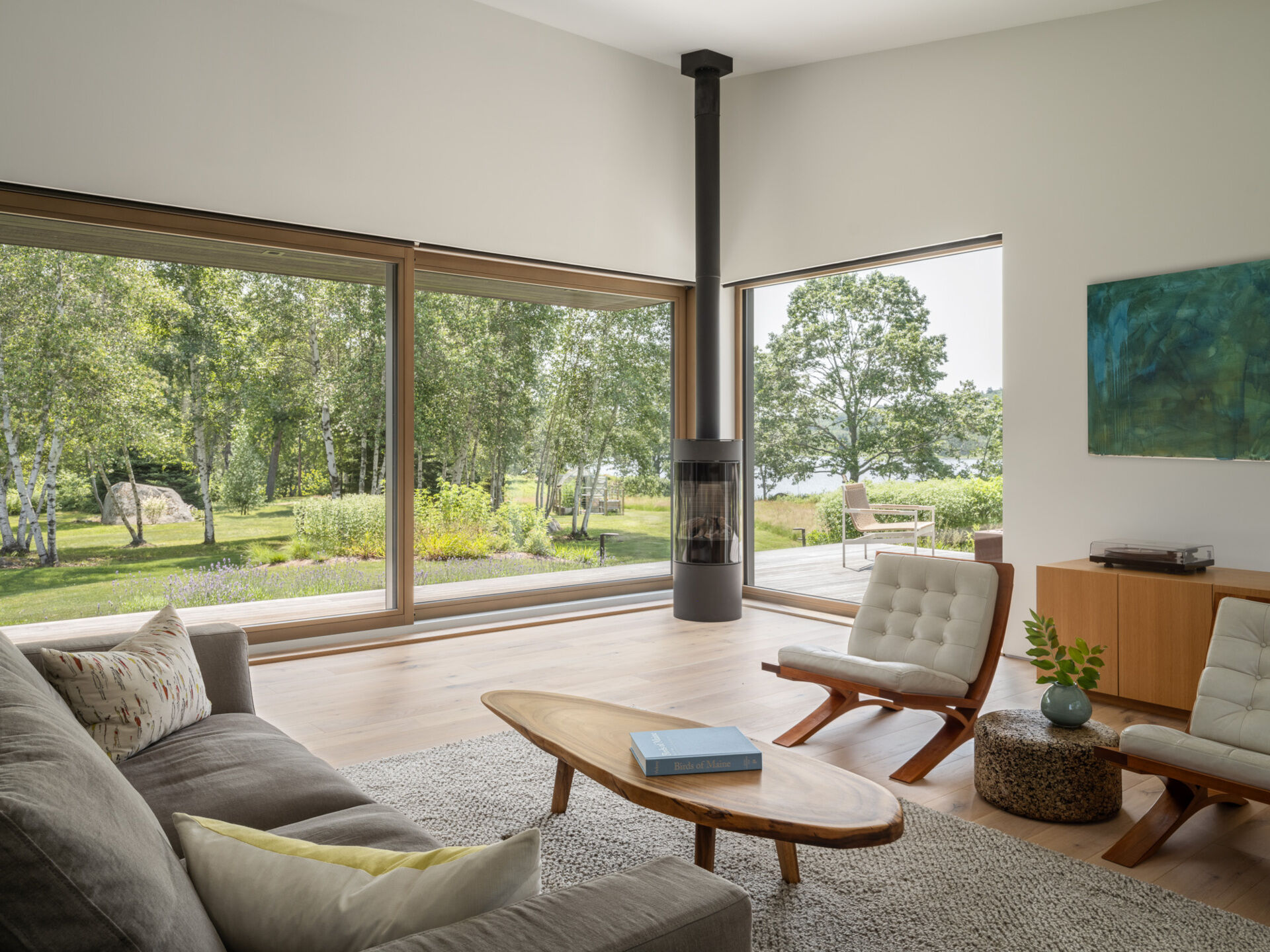 Bright white oak floors and triple-glazed windows create a warm, light-filled living room with ever-changing views of the Bagaduce River.