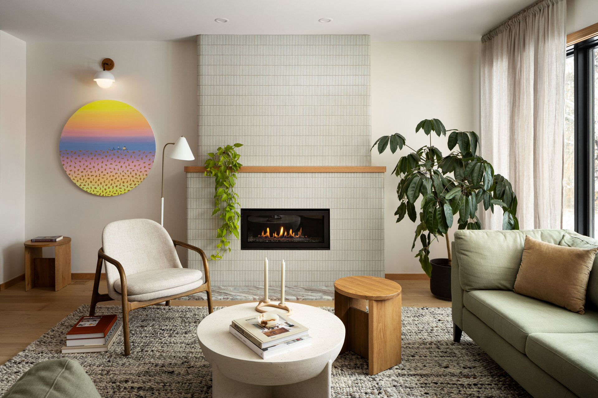 Anchoring the family room is a fireplace clad in slender Kit Kat-style tiles, adding both texture and subtle movement to the space. The vertical lines of the tile echo the curved forms used throughout the home, offering a modern yet inviting focal point. Rather than dominating the room, the fireplace quietly grounds it, warm, sculptural, and refined.